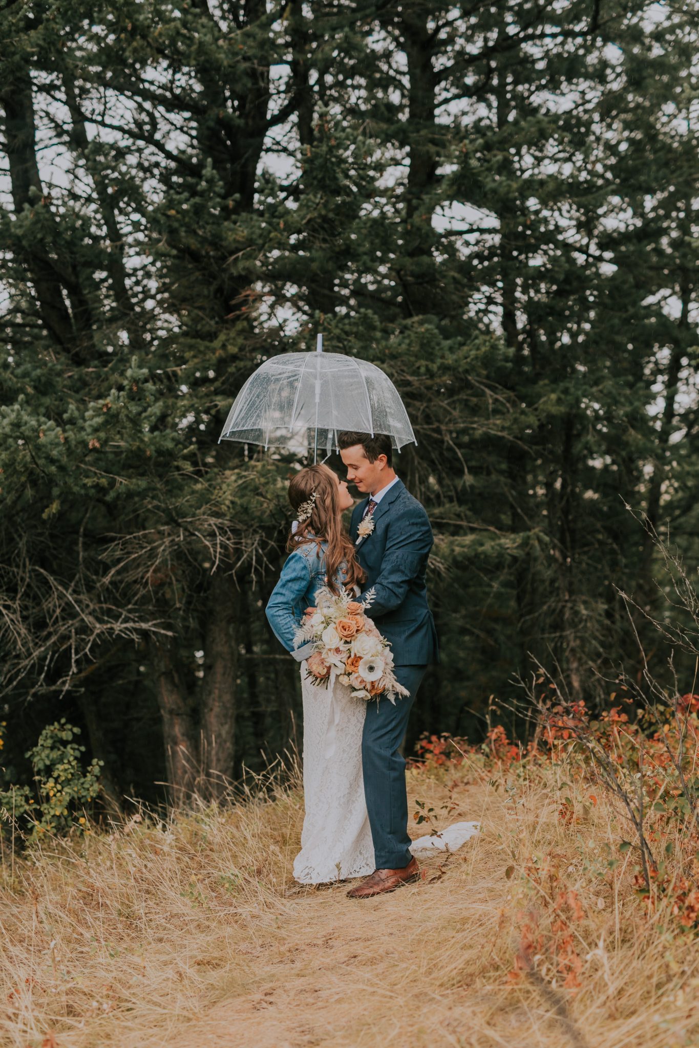 Romantic wedding in the rain, clear umbrella, jean jacket