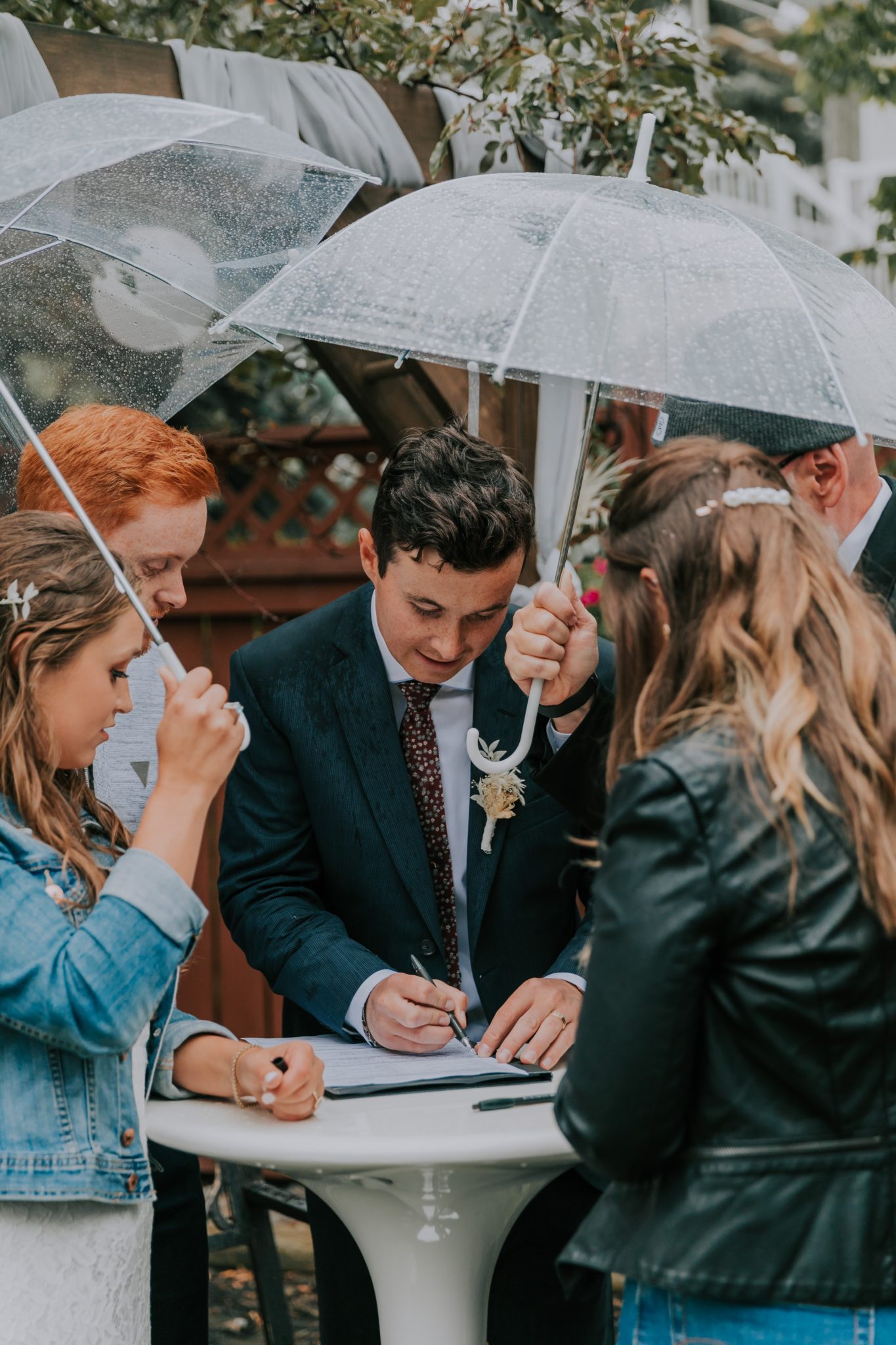 A Little Bit of Rain and Covid Restrictions weren't about to Slow This Couple Down! Featured on Brontë Bride, clear umbrella, rainy wedding
