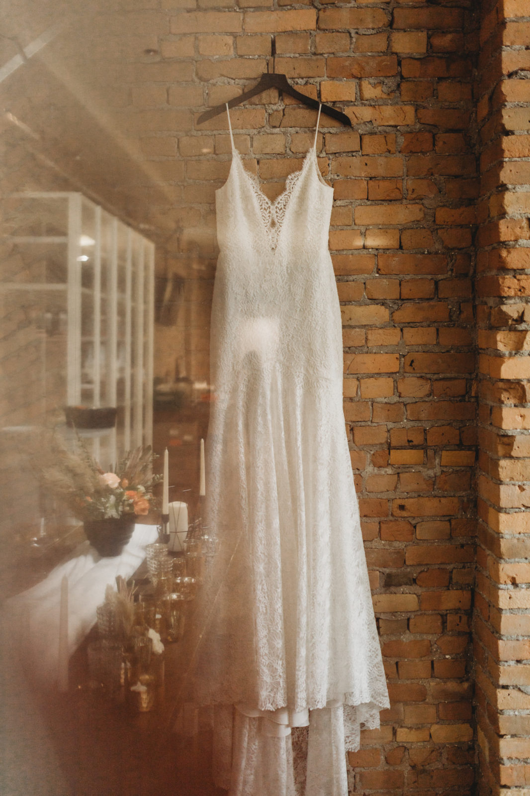 Lace dress by Anais Anette Flagship hangs against a brick wall at The Garett