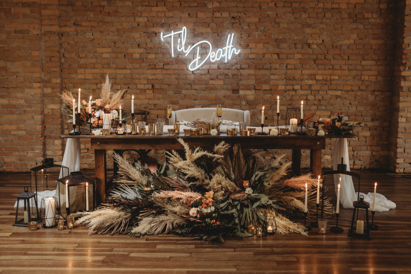 Till Death neon sign hangs above a dried floral styled sweetheart table at The Garret