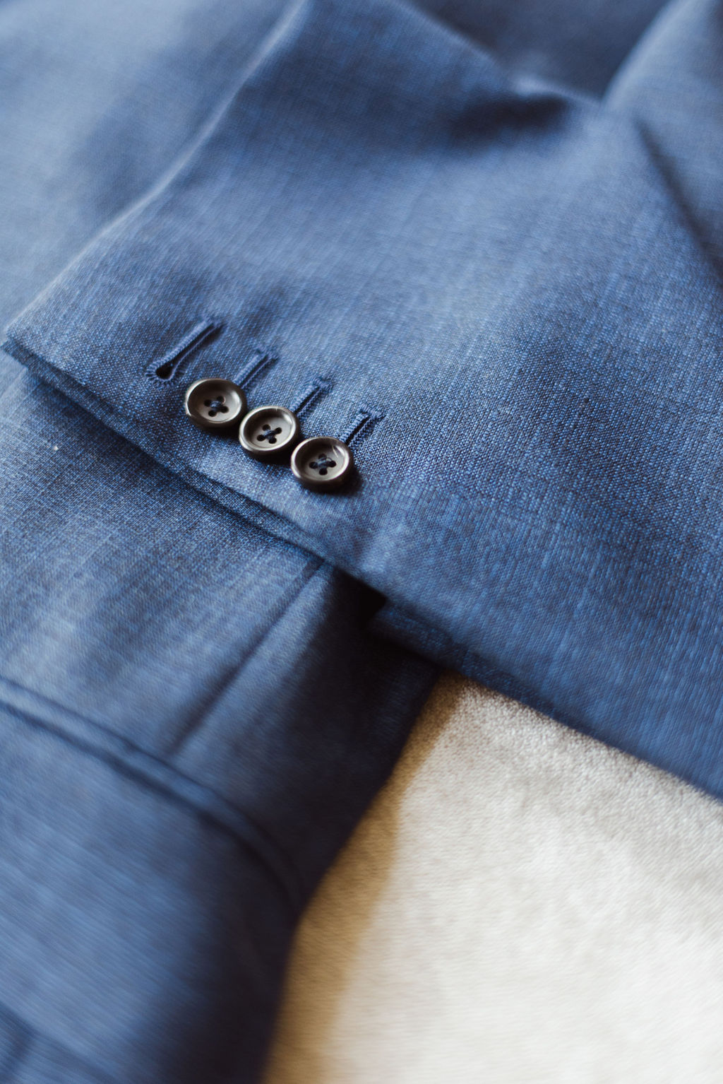 A blue suit with gunmetal silver buttons on the cuff