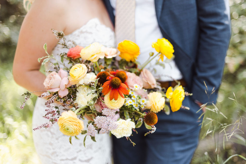 Whimsical flower bouquet by Faint Floral filled with hues of tangerine, blush, olive and yellows