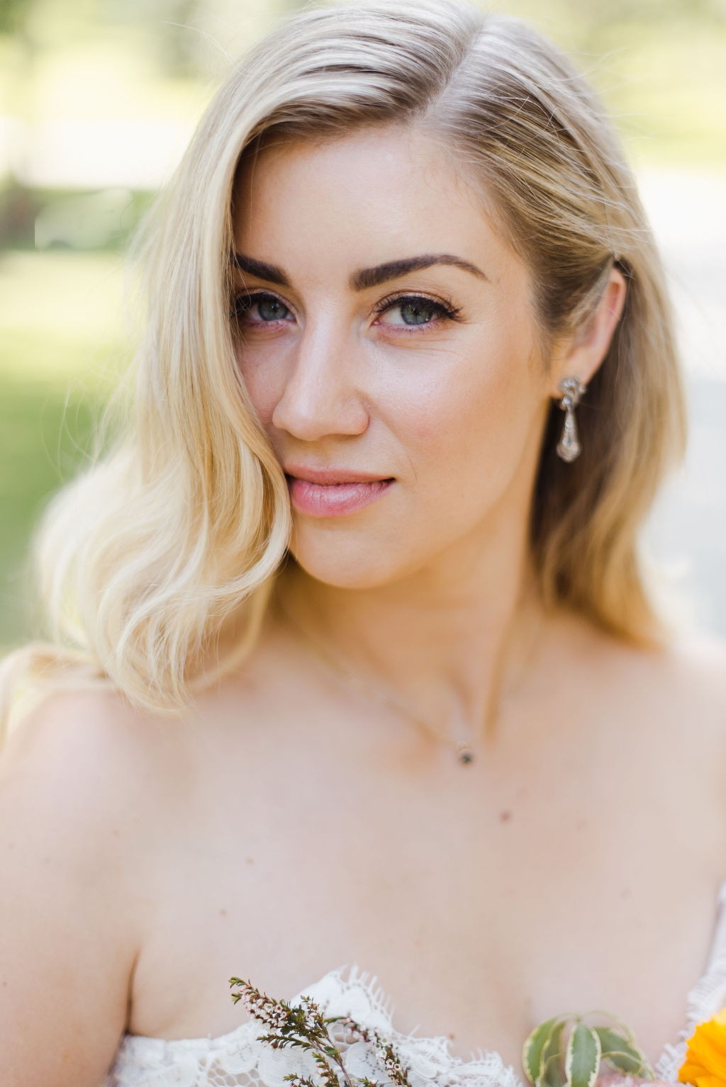 Blonde bride with romantic wavy hair poses for a portrait on her Calgary wedding day