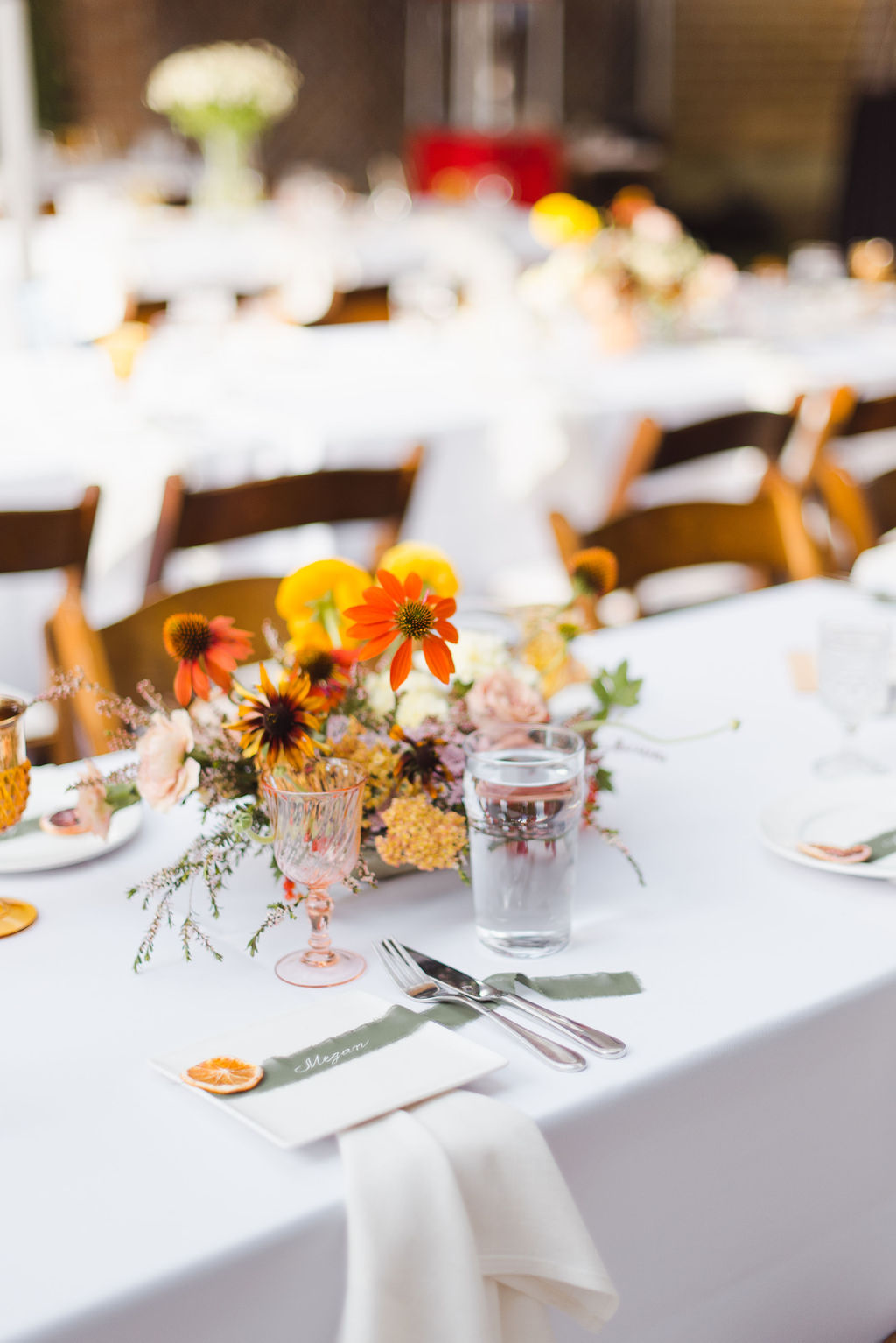 Bright orange whimsical wedding flowers photographed against an Italian inspired tablescape for a Calgary Alberta wedding