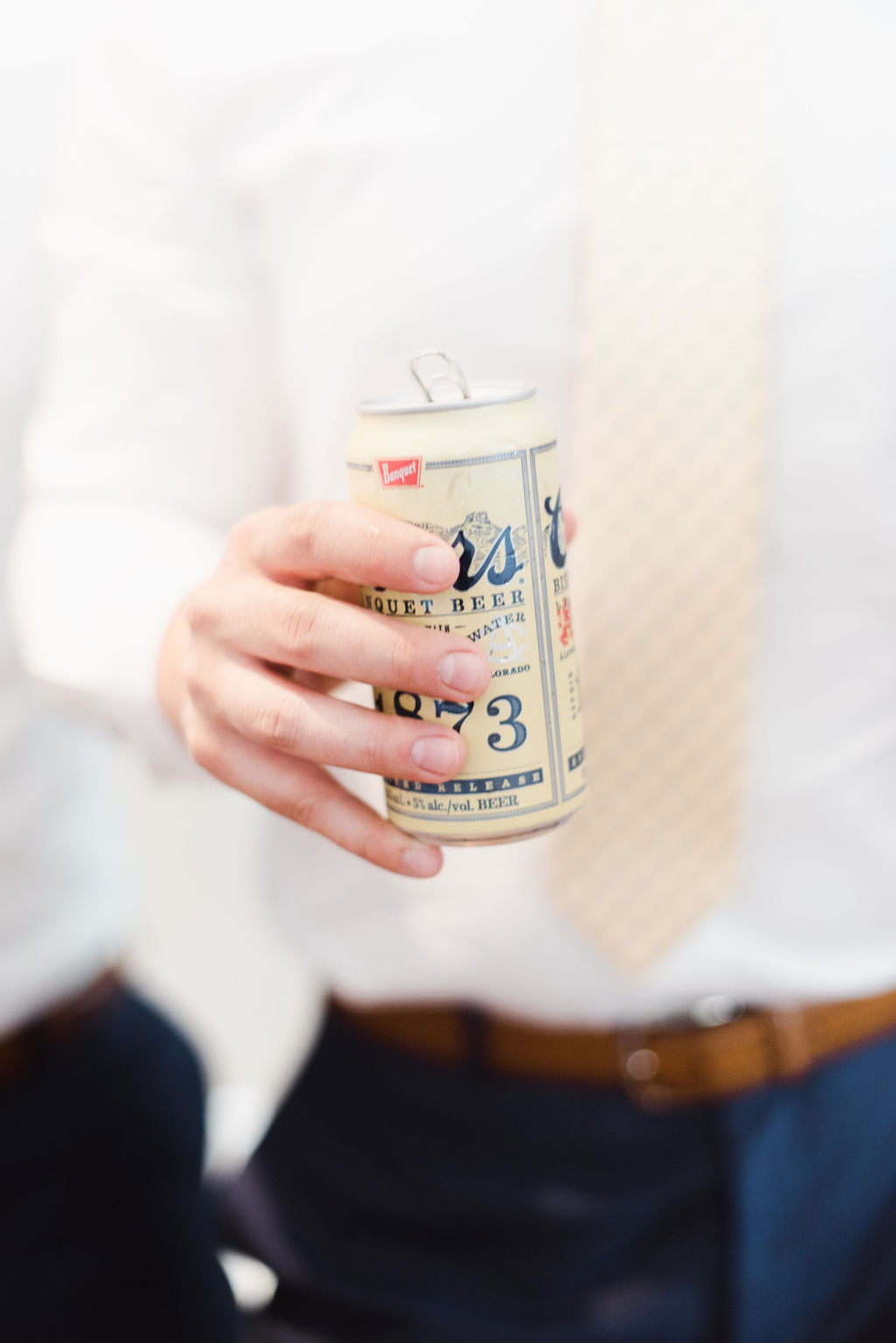 A groom drinks Coors Light on his wedding day