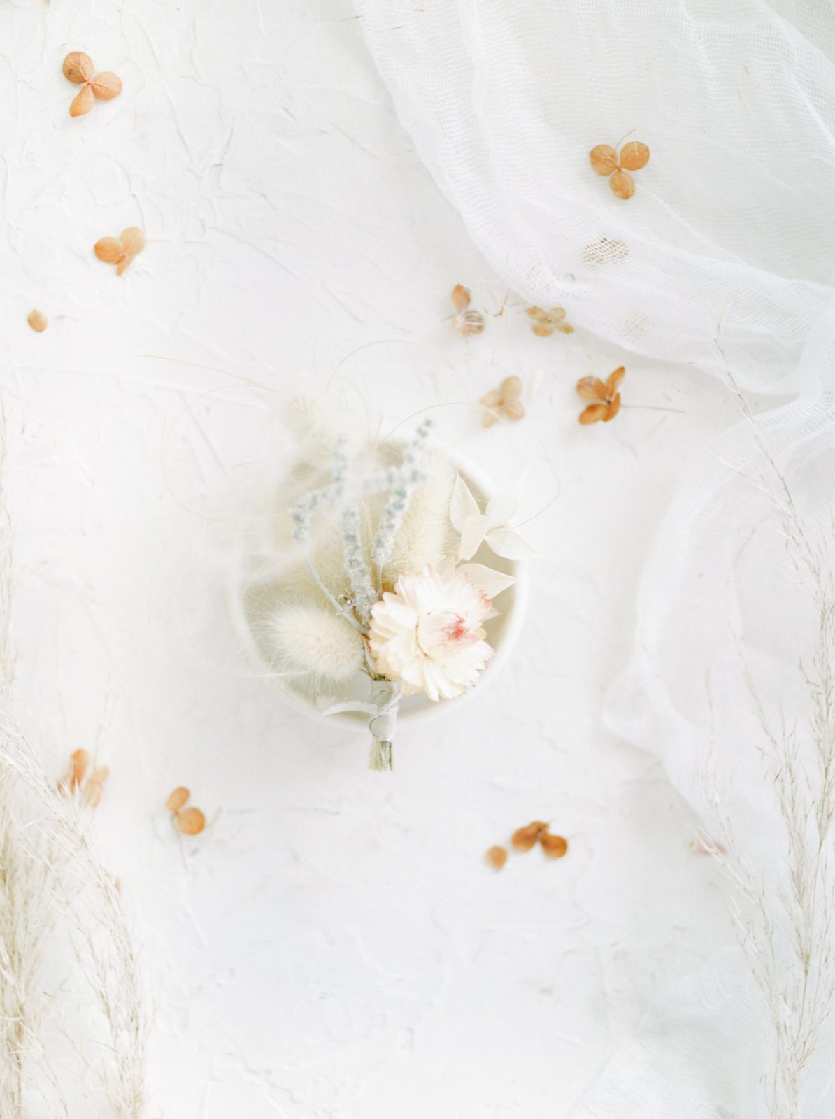 Boho boutonnière from Minim Designs styled against a romantic white backdrop