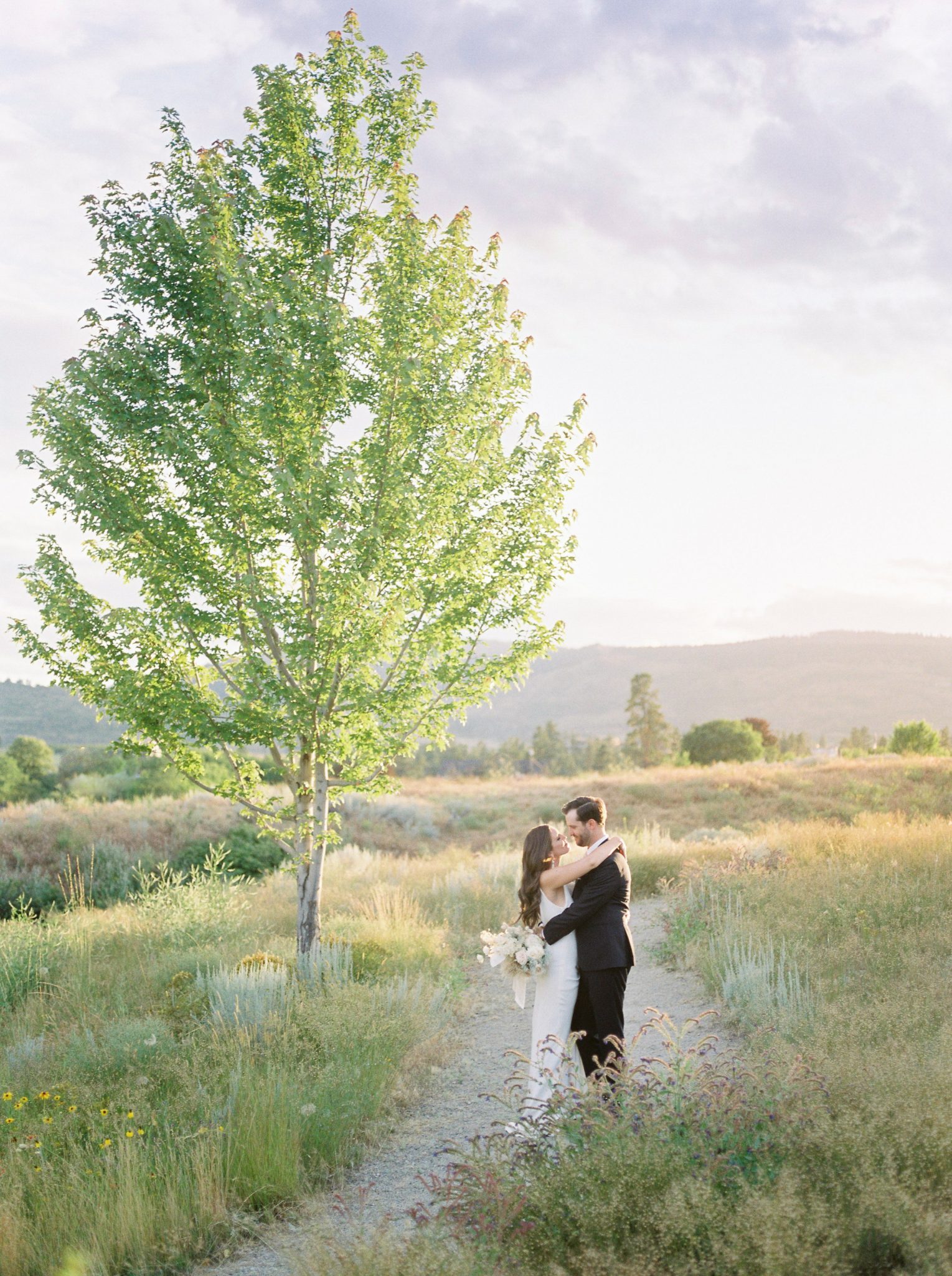 Bride and groom pose for sunset portraits in the rolling Okanagan hills