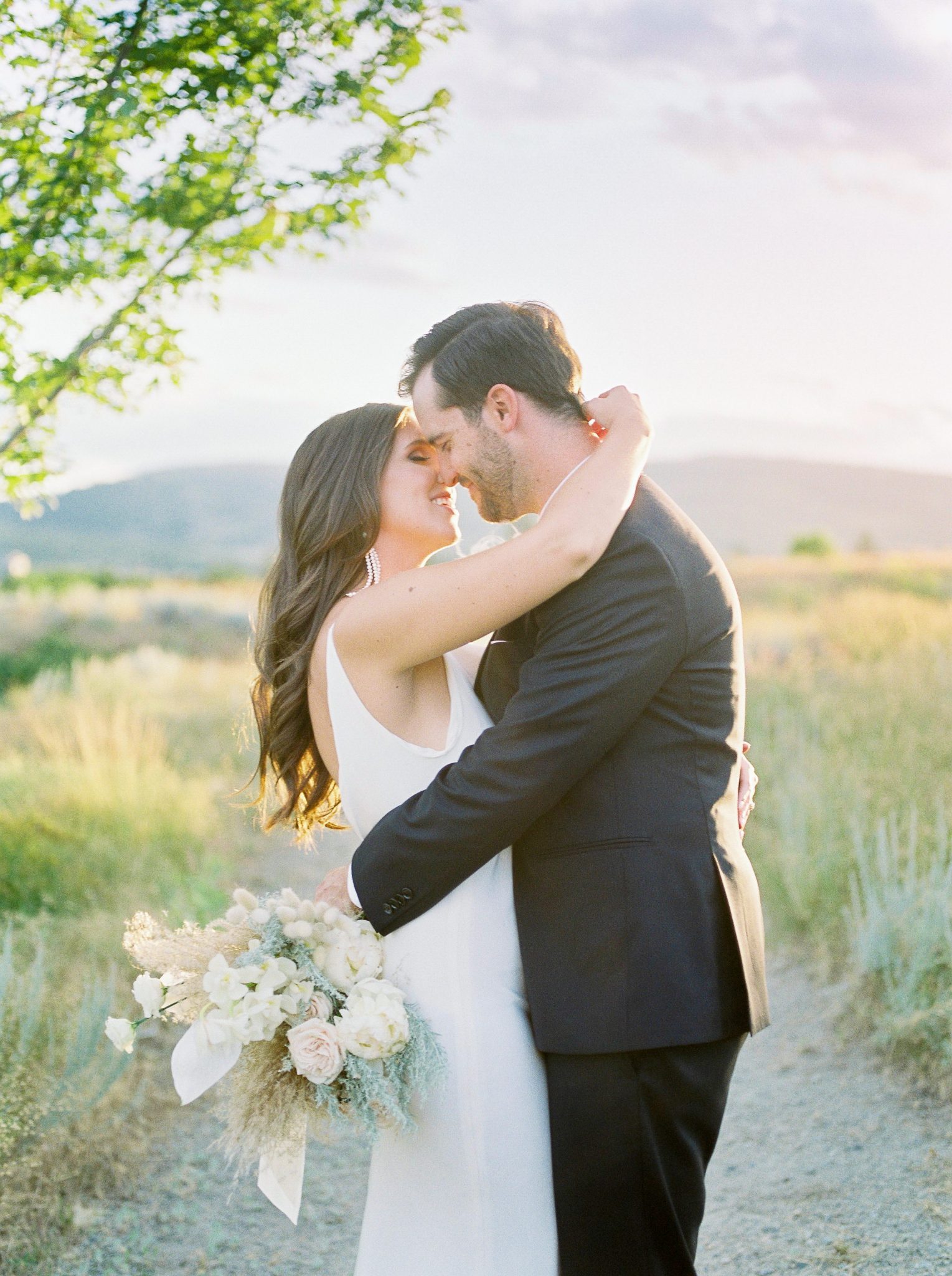 Bride and groom pose at sunset in the rolling hills of the Okanagan
