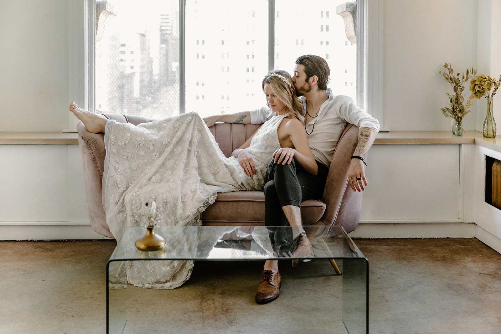 Bride and groom pose on a purple loveseat for their modern Vancouver elopement