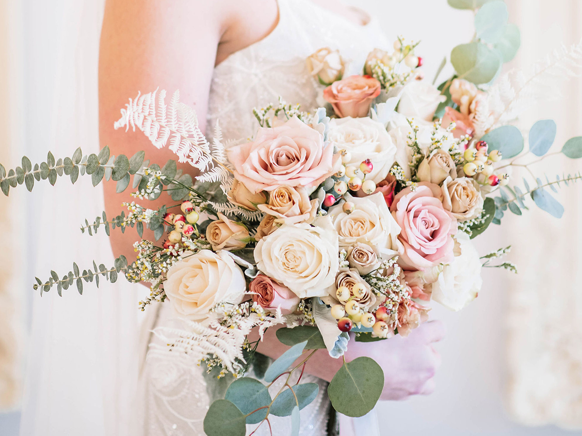 Blush bridal bouquet featuring spray roses, quicksand roses and dried botanicals