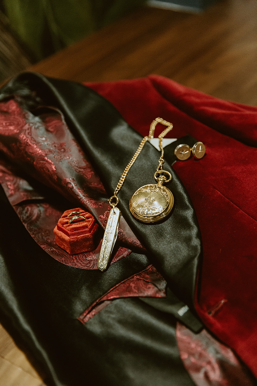 Crimson and gold groom attire details with a pocket watch