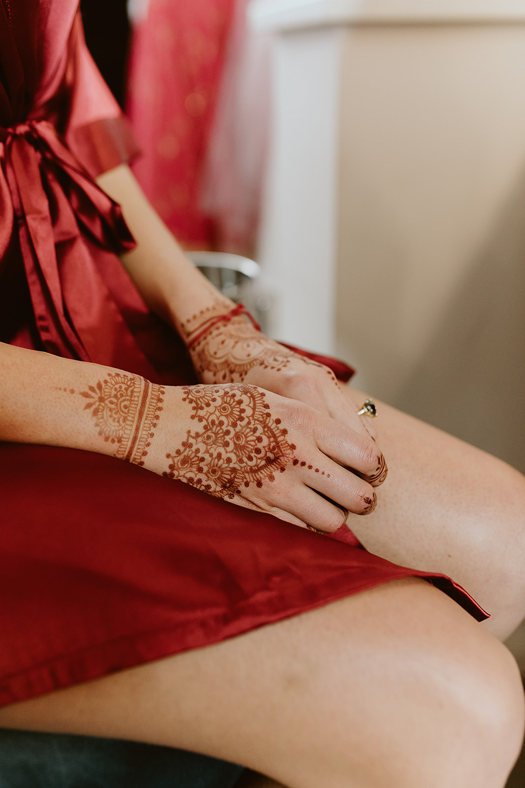 Henna hands for a bride in a crimson silk robe
