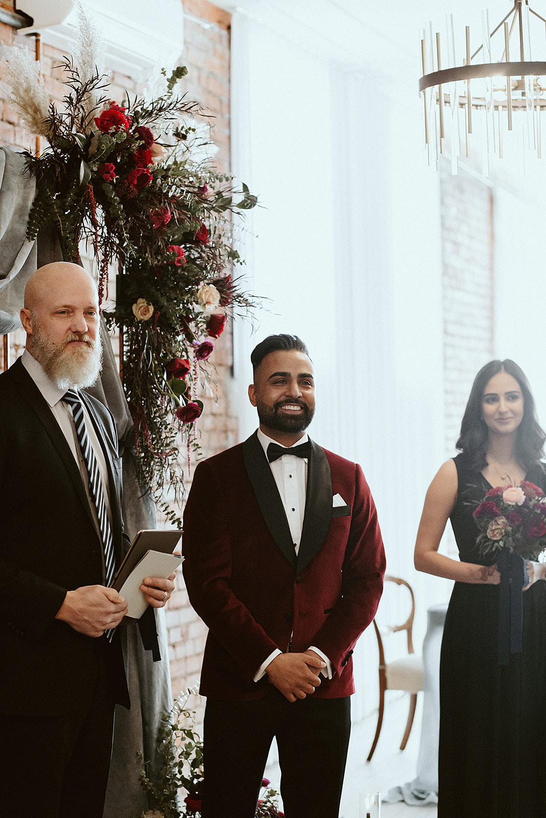 Groom in a crimson red suit sees his bride for the first time at this multicultural minimony at Venue 308 in Calgary Alberta