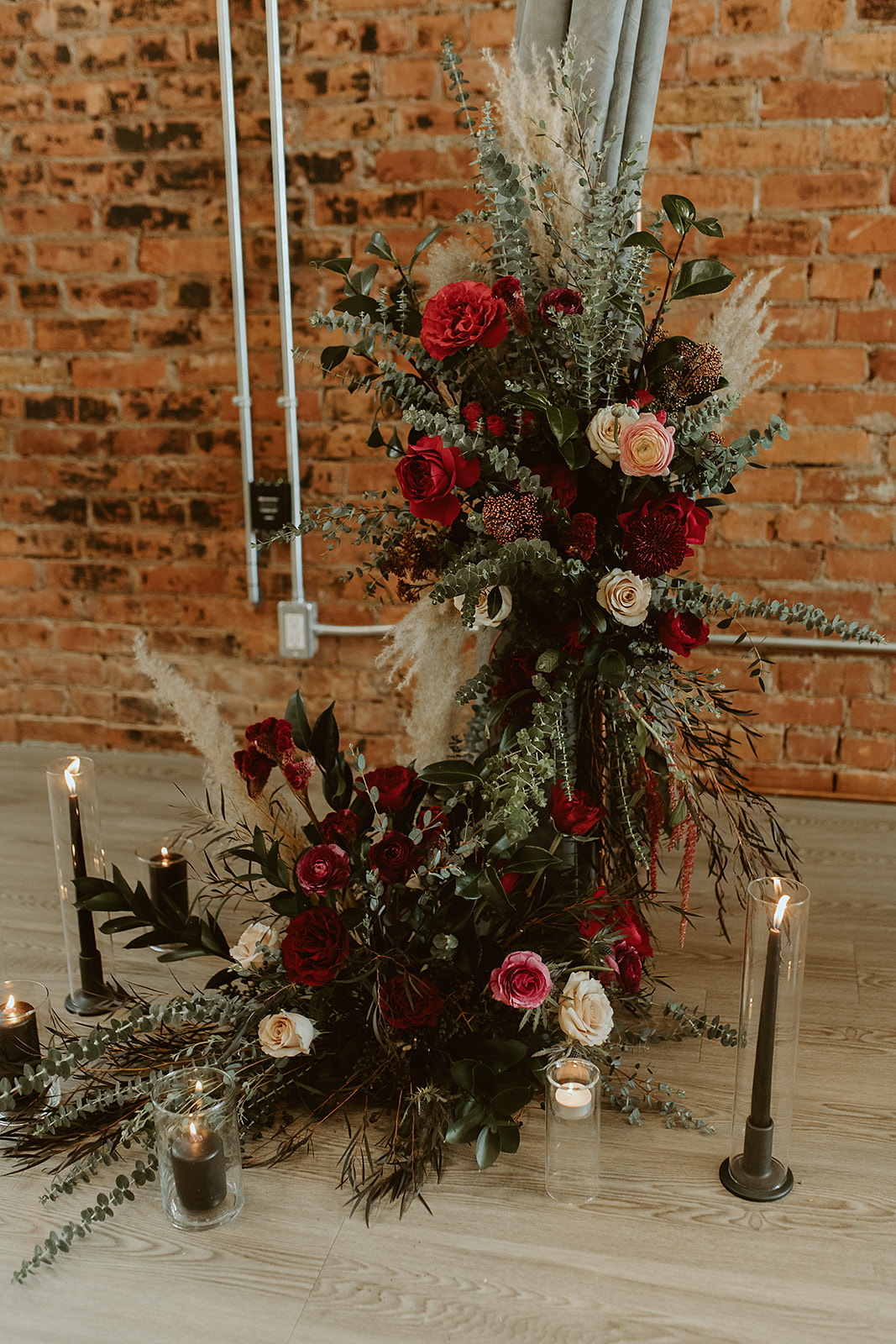 Boho rich jewell tone wedding decor at Venue 308 with black candle sticks and green drapery