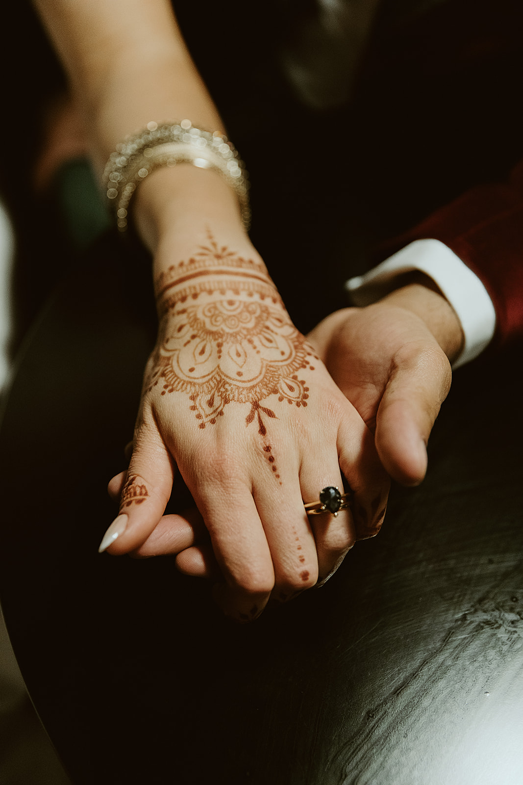 Bride with henna hands and a black engagement ring