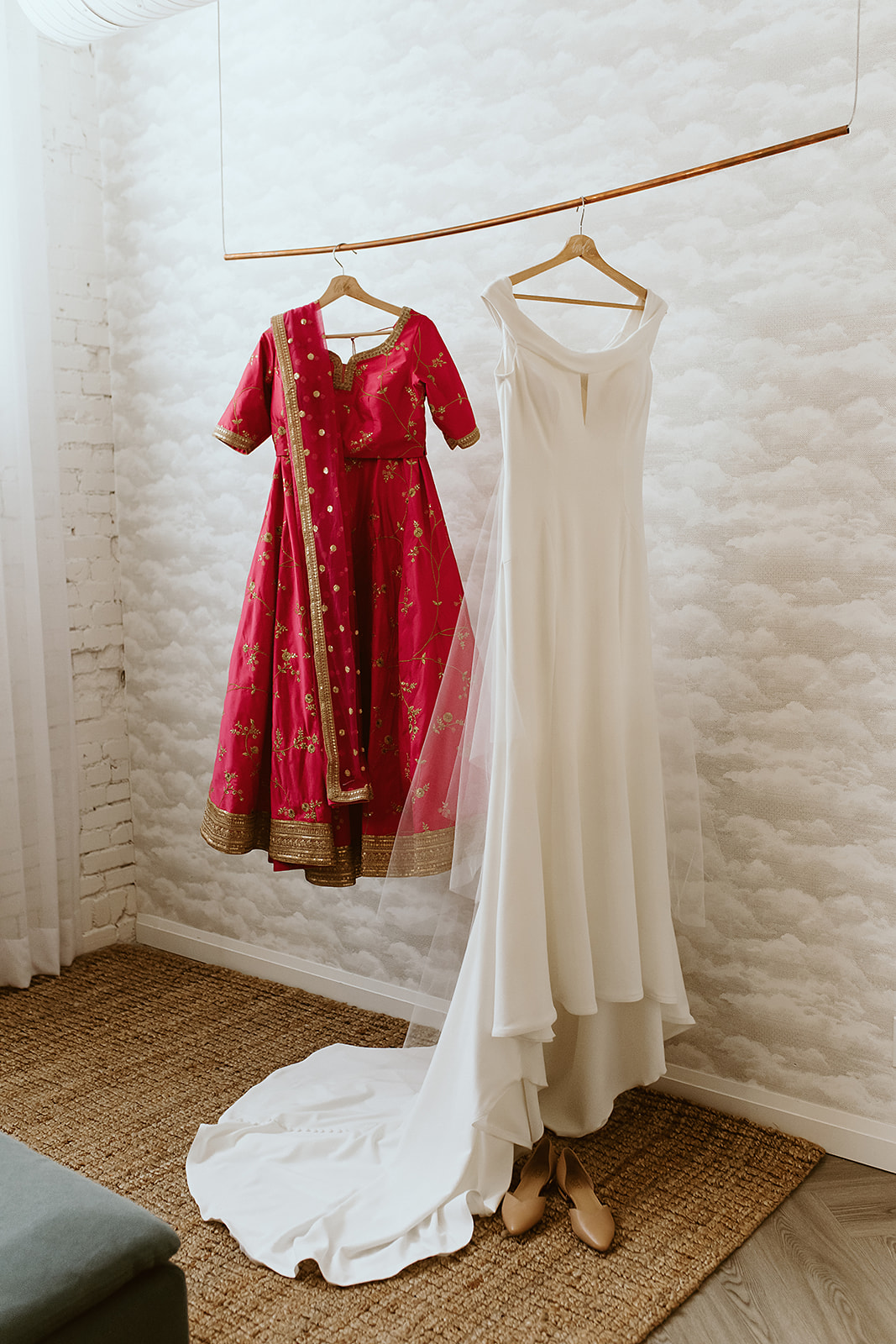 White wedding dress hung at Venue 308 next to a traditional fuchsia lehenga for a multicultural minimony
