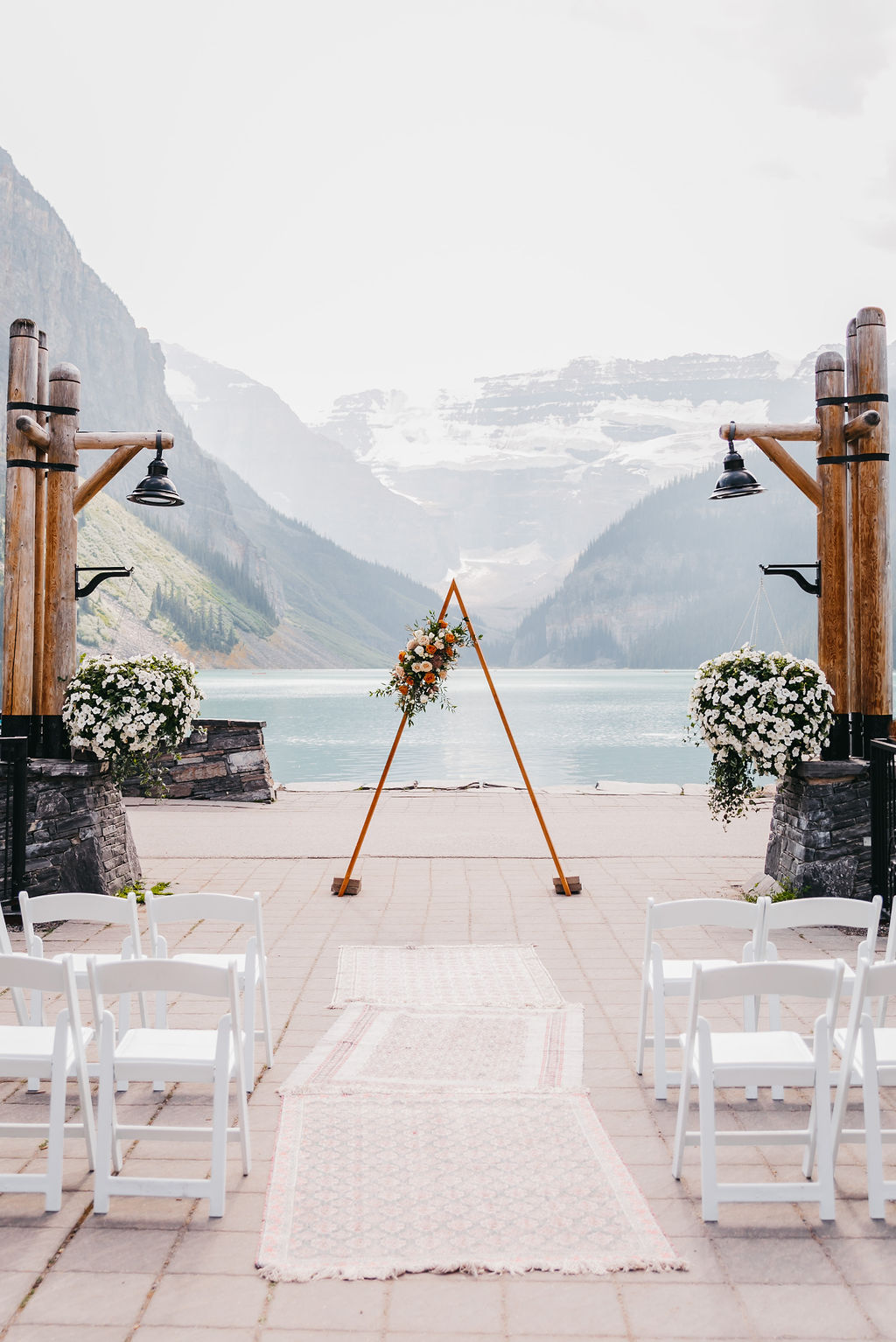 Triangle wedding ceremony arch adorned with flowers at Lake Louise