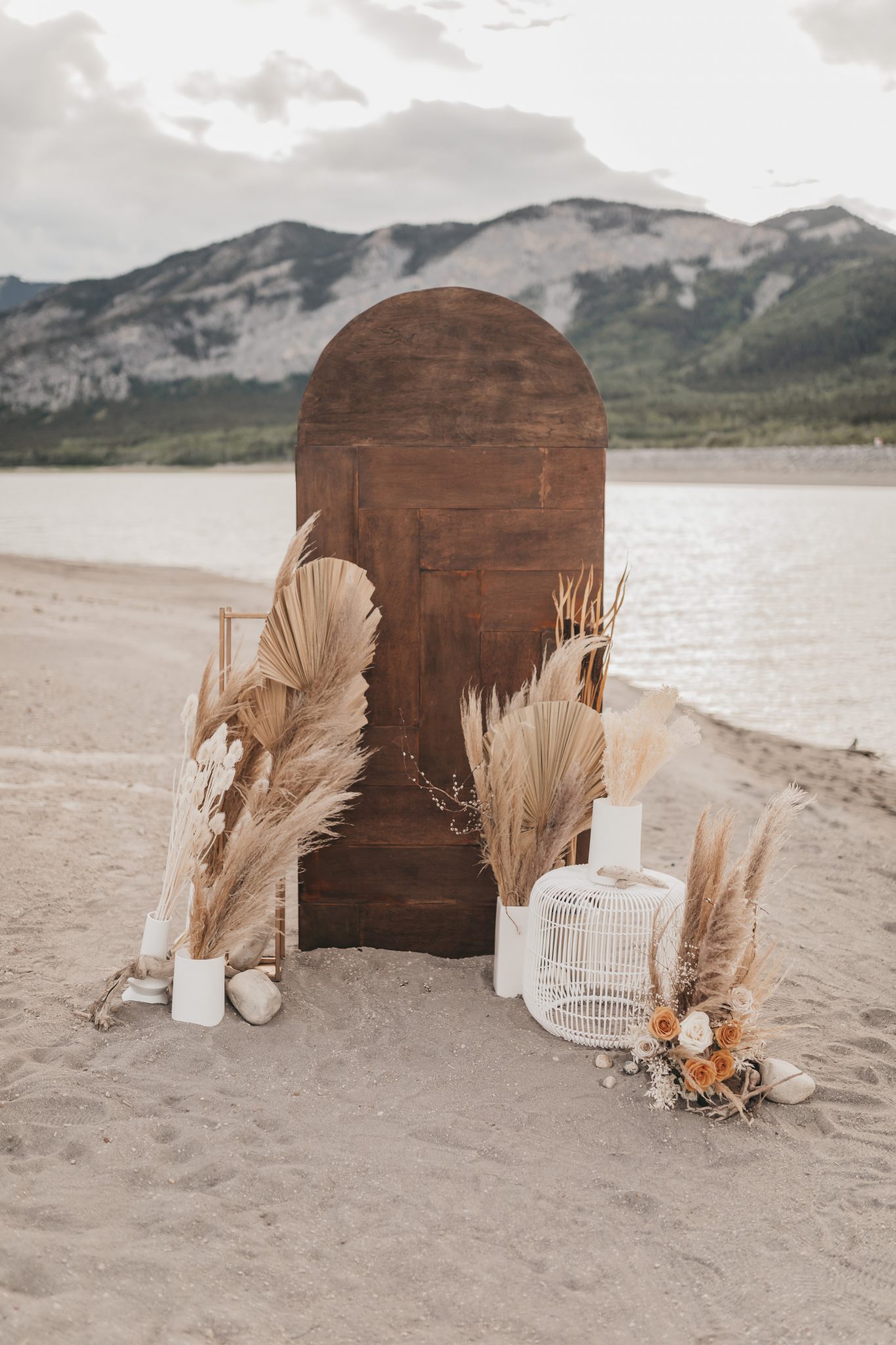 Boho styled wooden ceremony panel styled with boho dried palms
