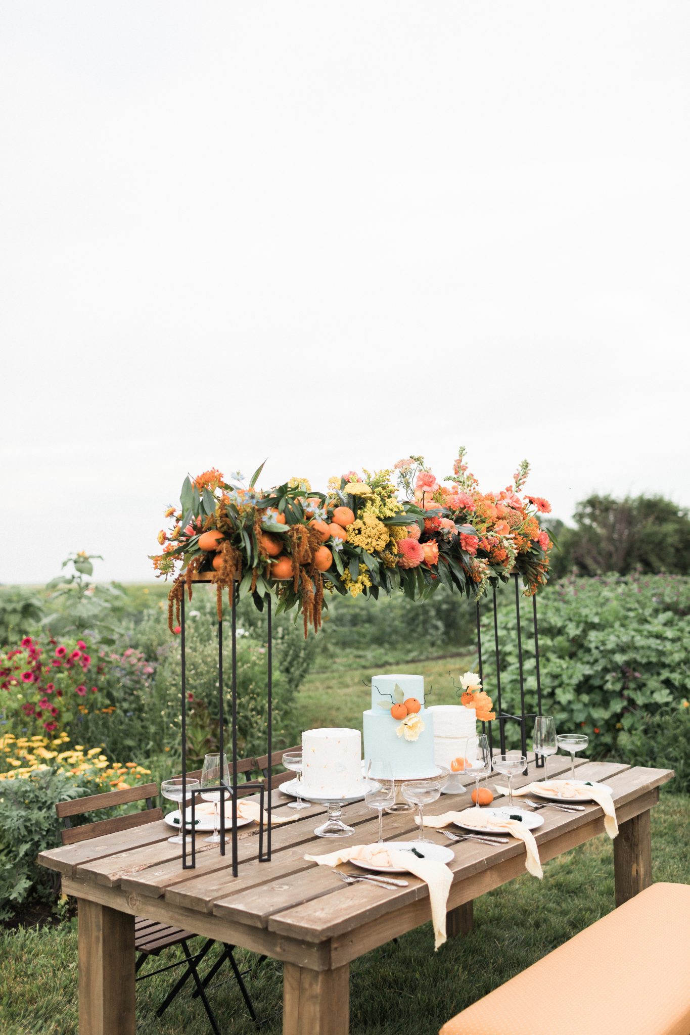 Garden inspired tablescape for a countryside wedding with tangerine accents and a robin blue wedding cake