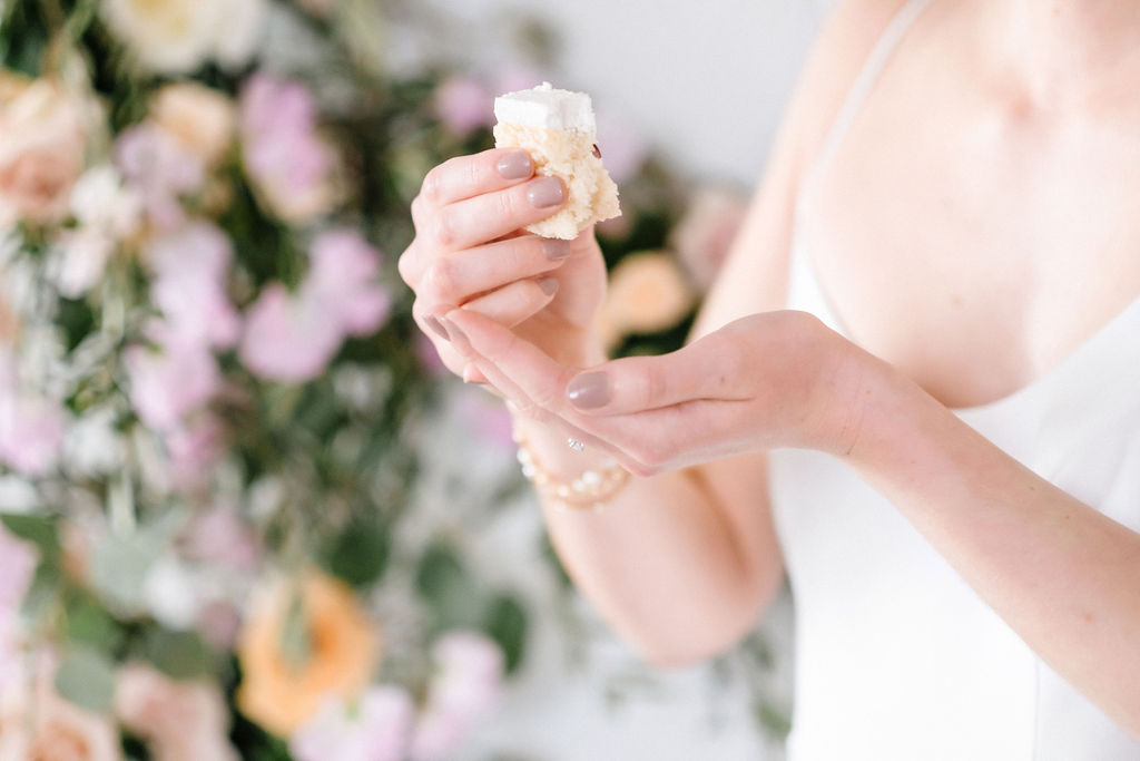 Bride holds a piece of wedding cake