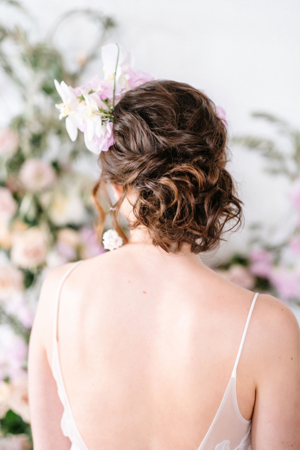 Romantic bridal updo with an orchid floral crown by Creative Edge Flowers