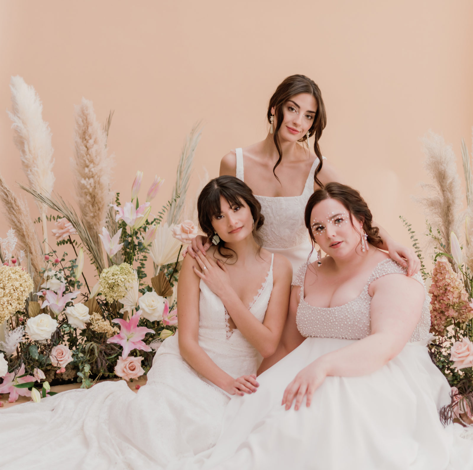 Three models pose together showcasing Lovenote Bride's newest wedding dress collection