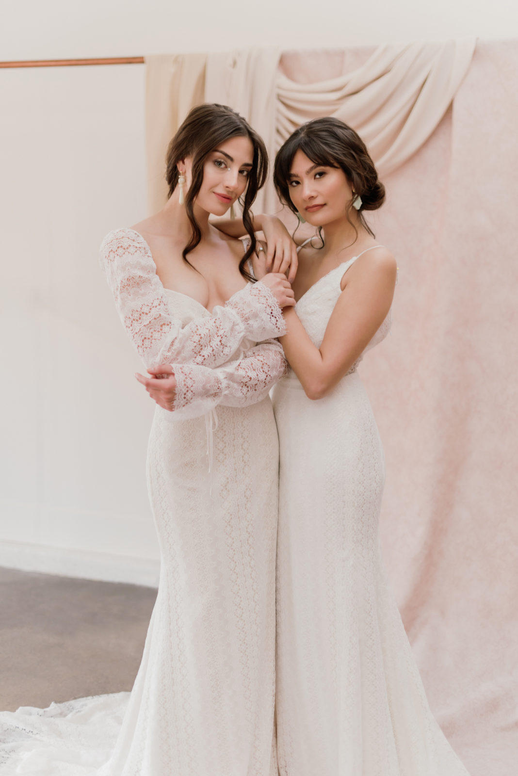 Two models pose together in renaissance inspired wedding gowns at Lovenote Bride in Calgary Alberta