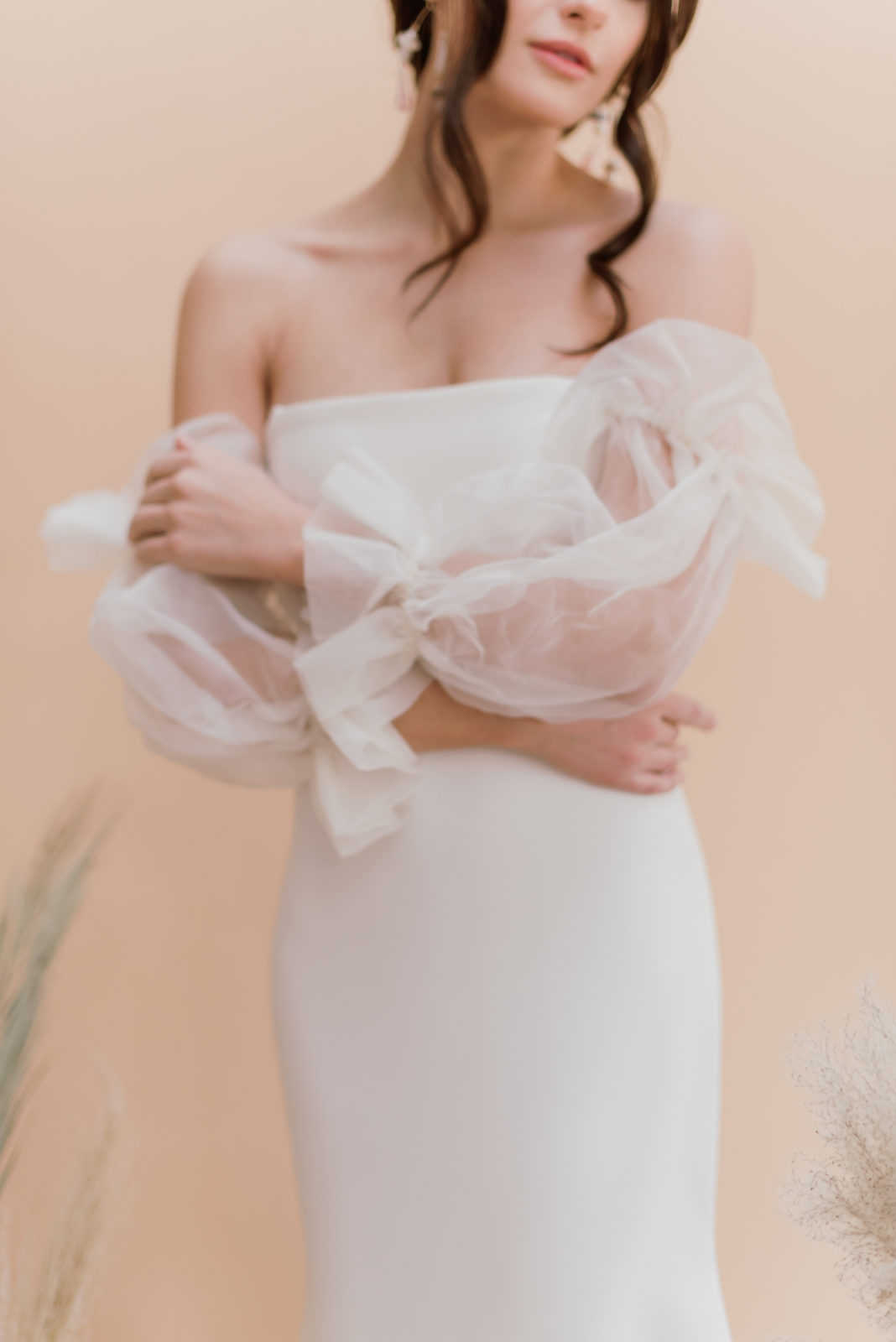 A model showcases the romantic and feminine fluffy sleeves of a renaissance inspired wedding gown