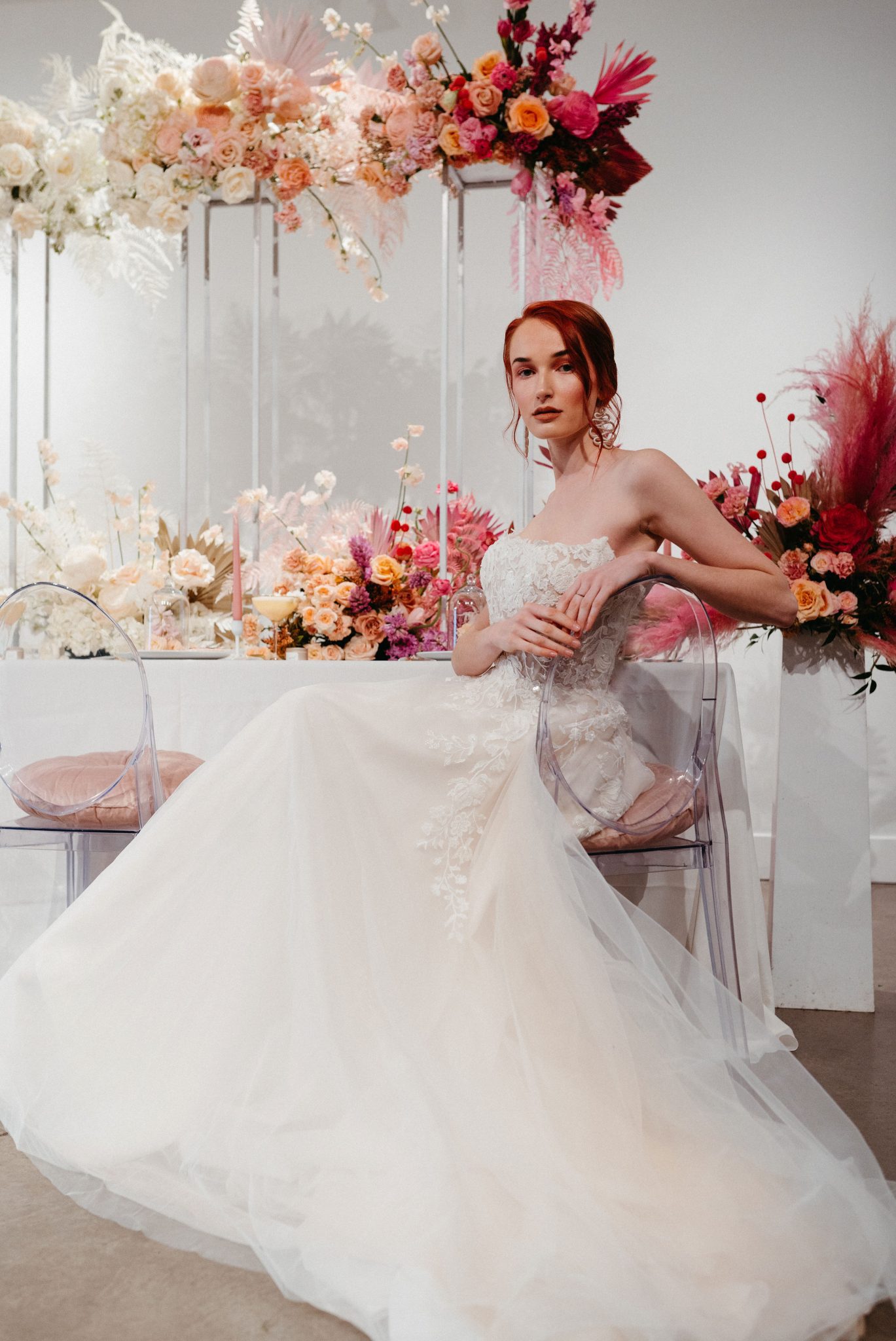 Bride poses in front of an ombre floral installation as wedding decor inspiration