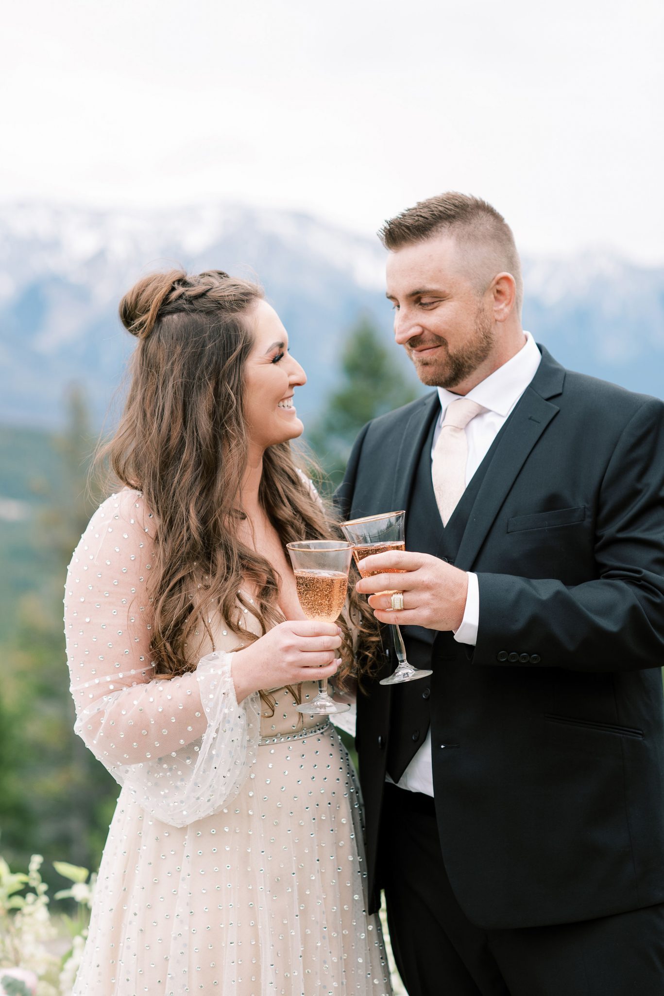 Bride and groom share a glass of champagne at Tunnel Mountain Reservoir 