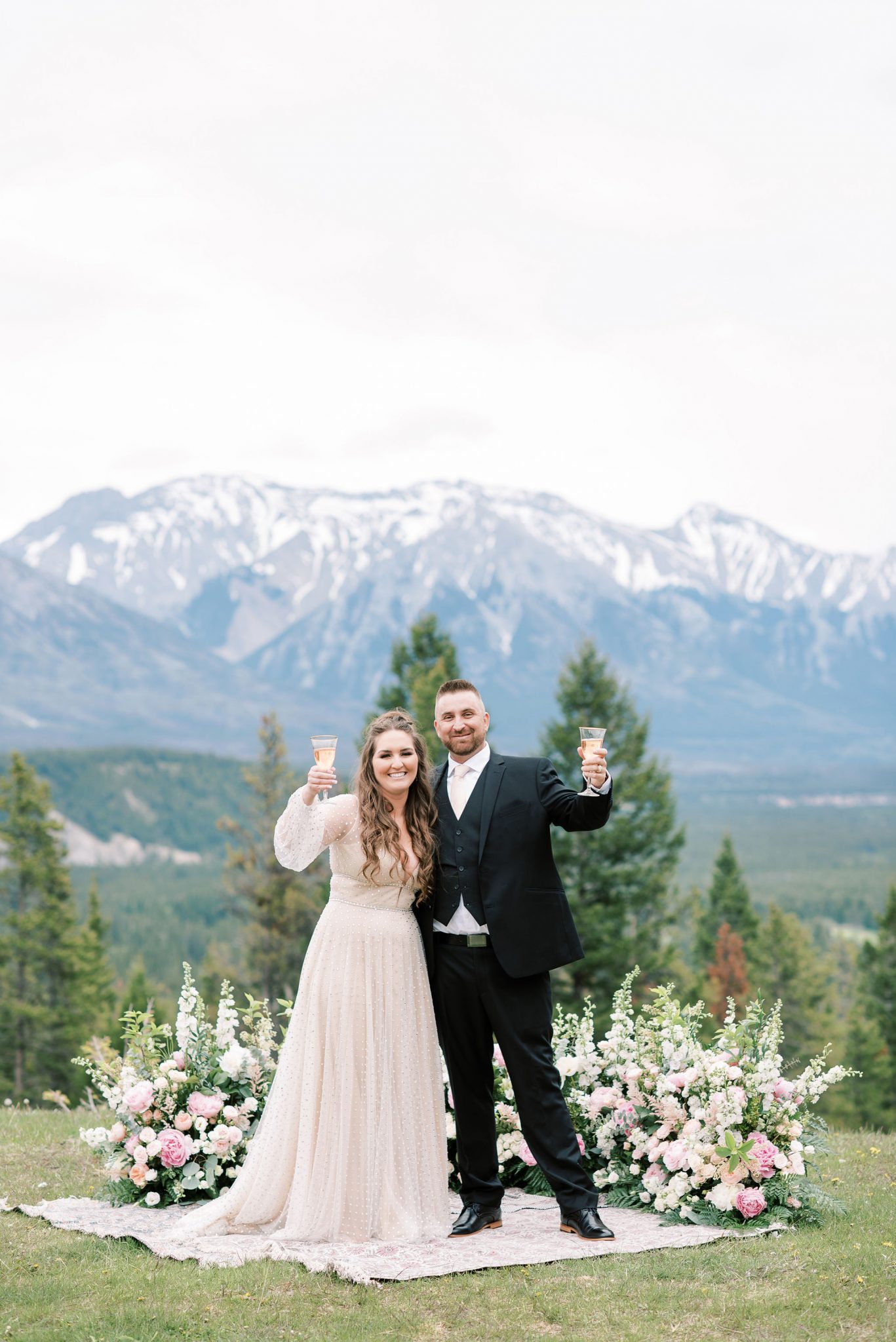 Newly eloped bride and groom toast with their champagne glasses at Tunnel Mountain Reservoir 