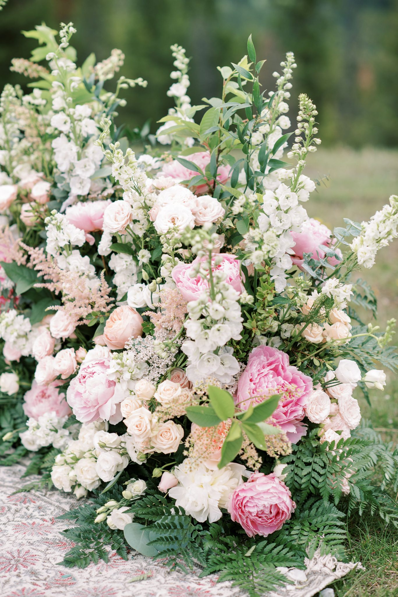 Pink and white grounded ceremony floral arch by Flowers by Janie