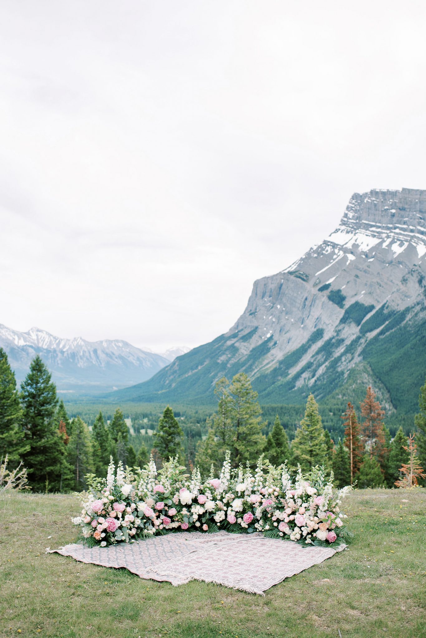 Grounded floral ceremony arch by Flowers by Janie for an elopement in Banff National Park