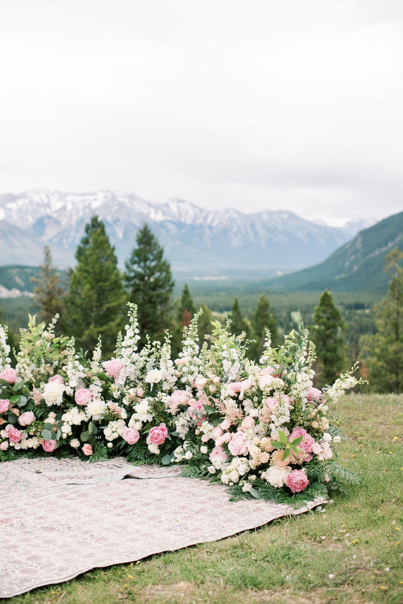 Grounded floral arch featuring blush and white blooms by Flowers by Janie for an intimate elopement in Banff National Park