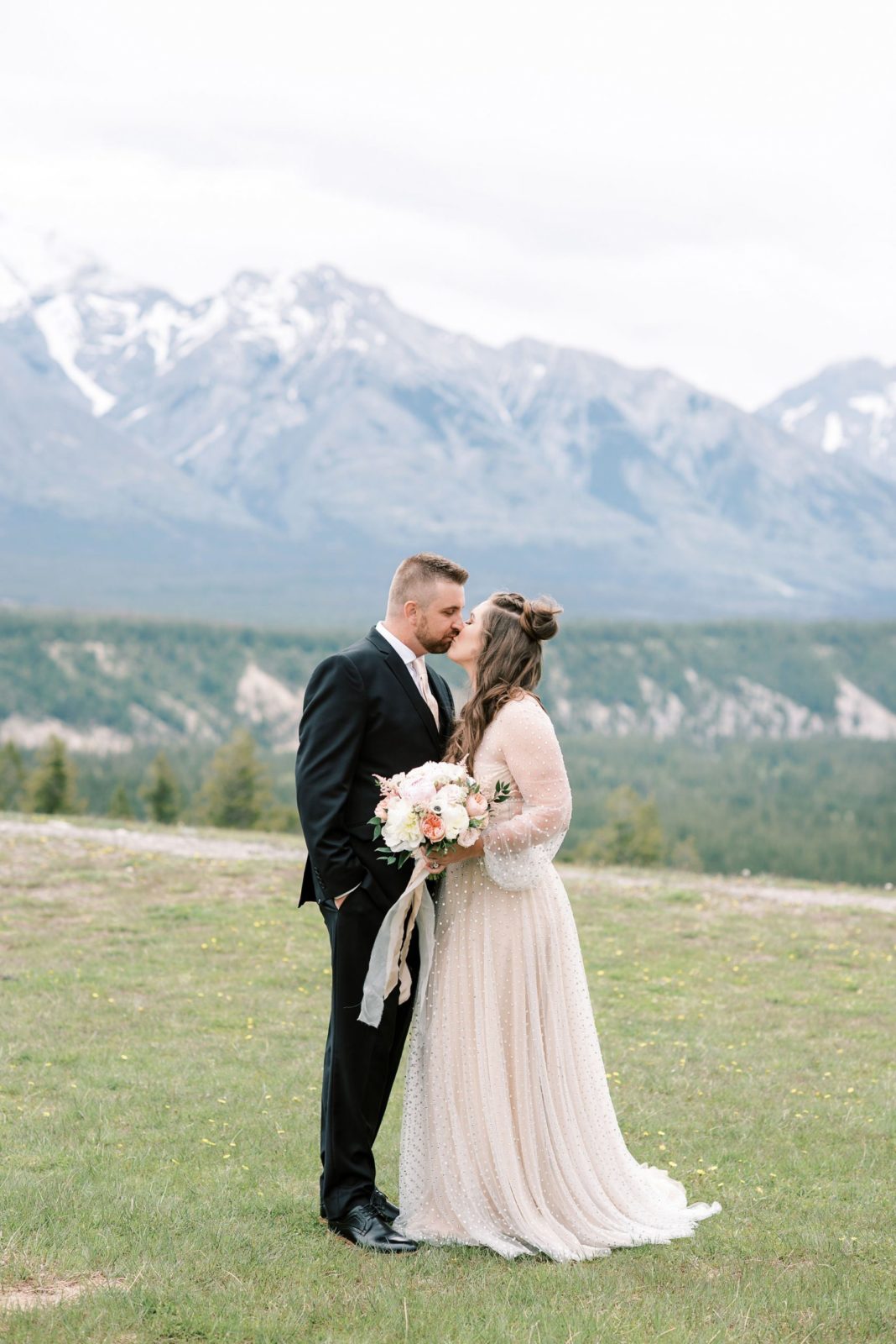 Newly weds elope at Tunnel Mountain reservoir with the mountains of Banff National Park in the background