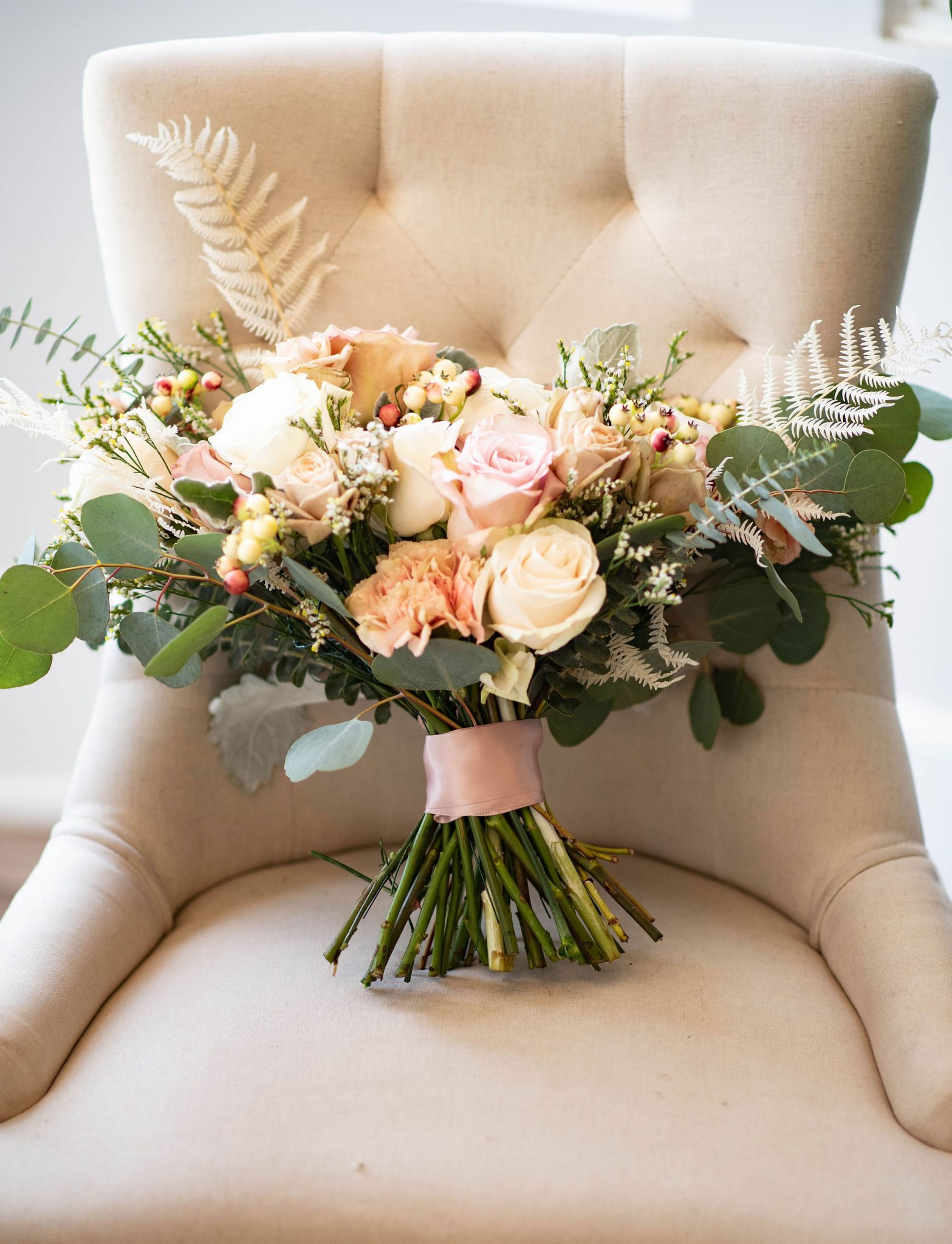 Blush bridal bouquet photographed on a champagne chaise chair
