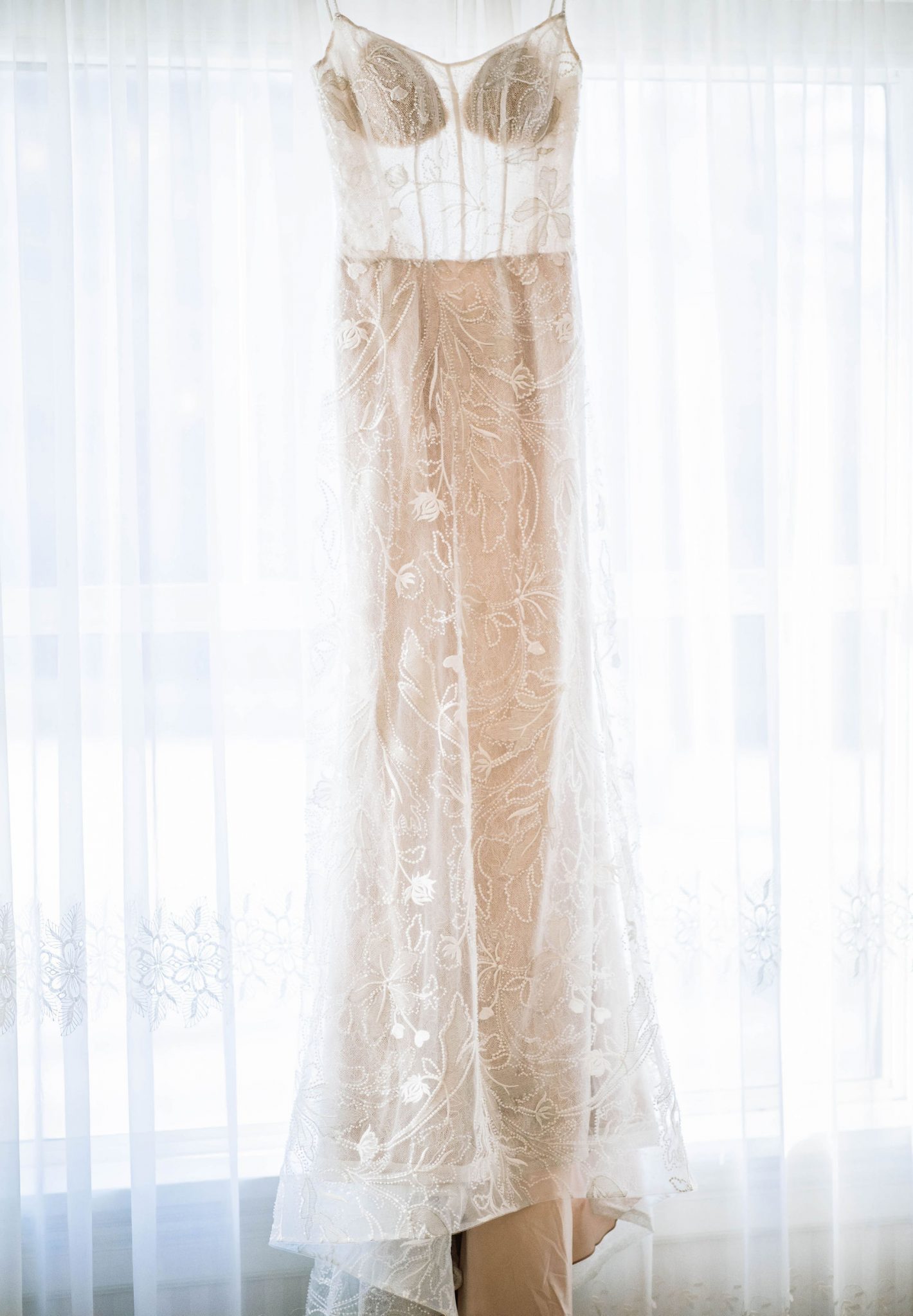 Lace off-white gown hangs in the window at the Norland Historic Estate Venue