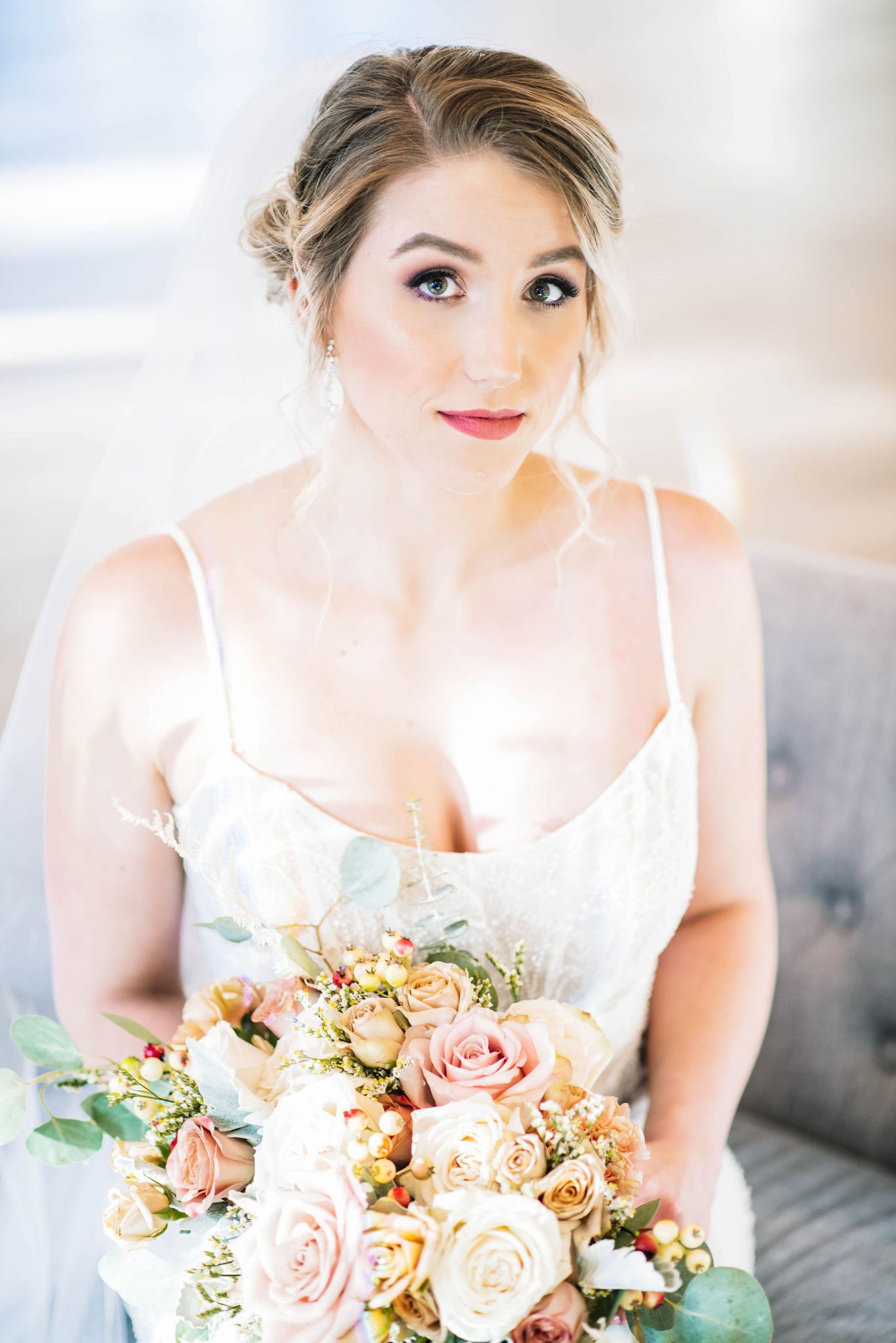 Bride with a romantic updo, soft flowing veil and blush bouquet poses for a bridal portrait at the Norland Historic Estate Venue