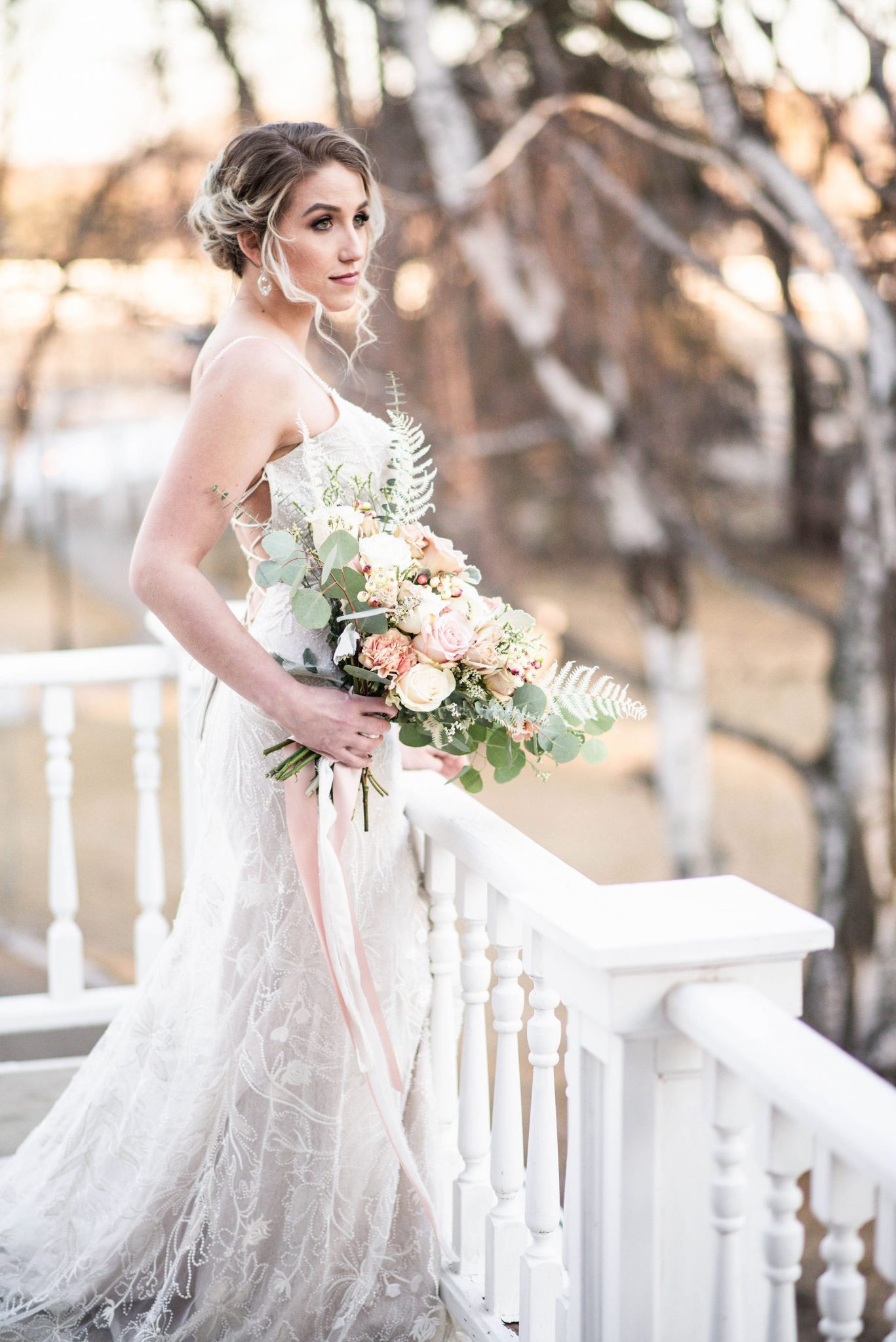 Classic winter bride with a romantic soft updo poses on the balcony of the Norland Historic Estate Venue