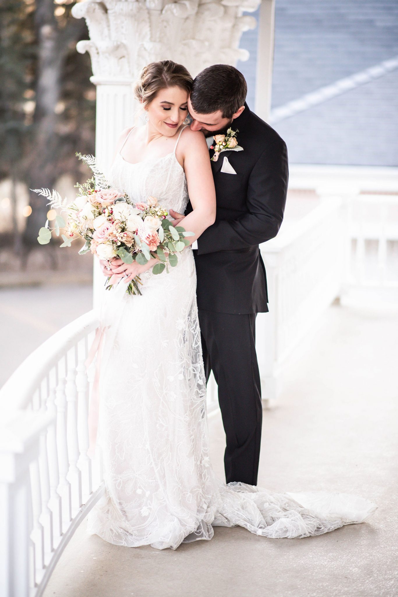 Classically styled bride and groom pose together on the romantic balcony at the Norland Historic Estate Venue