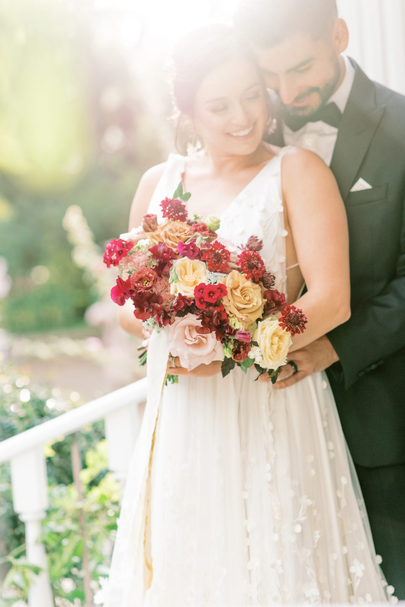 Bride and groom pose on the steps of the Norland Historic Estate for their enchanting estate wedding featuring a bridal bouquet inspired by berry hues and honey