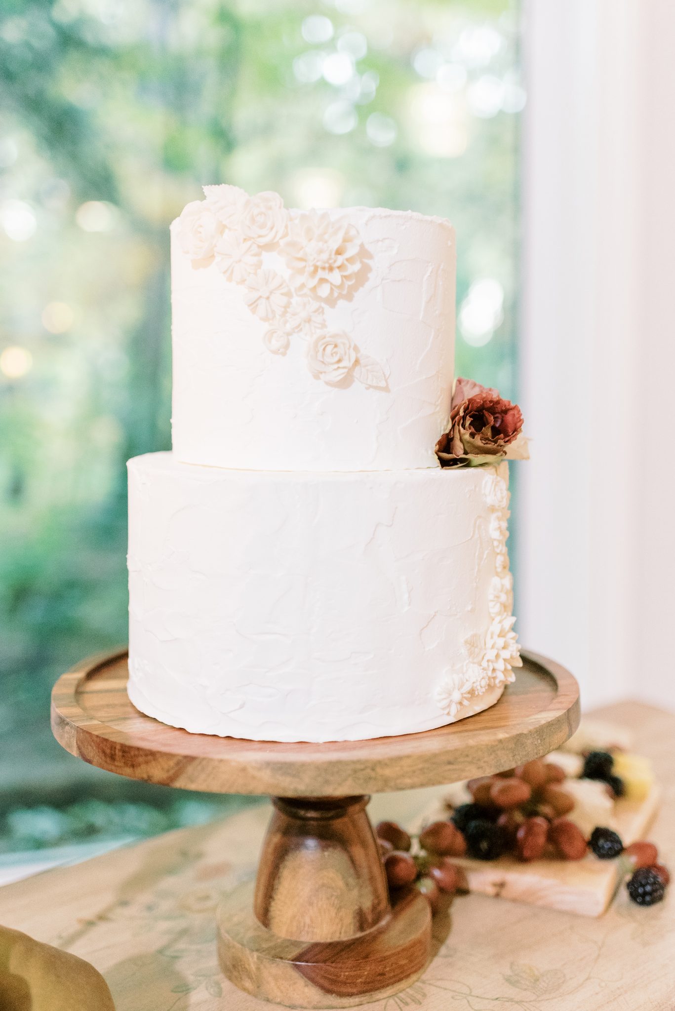 White two tiered cake featuring delicate floral designs