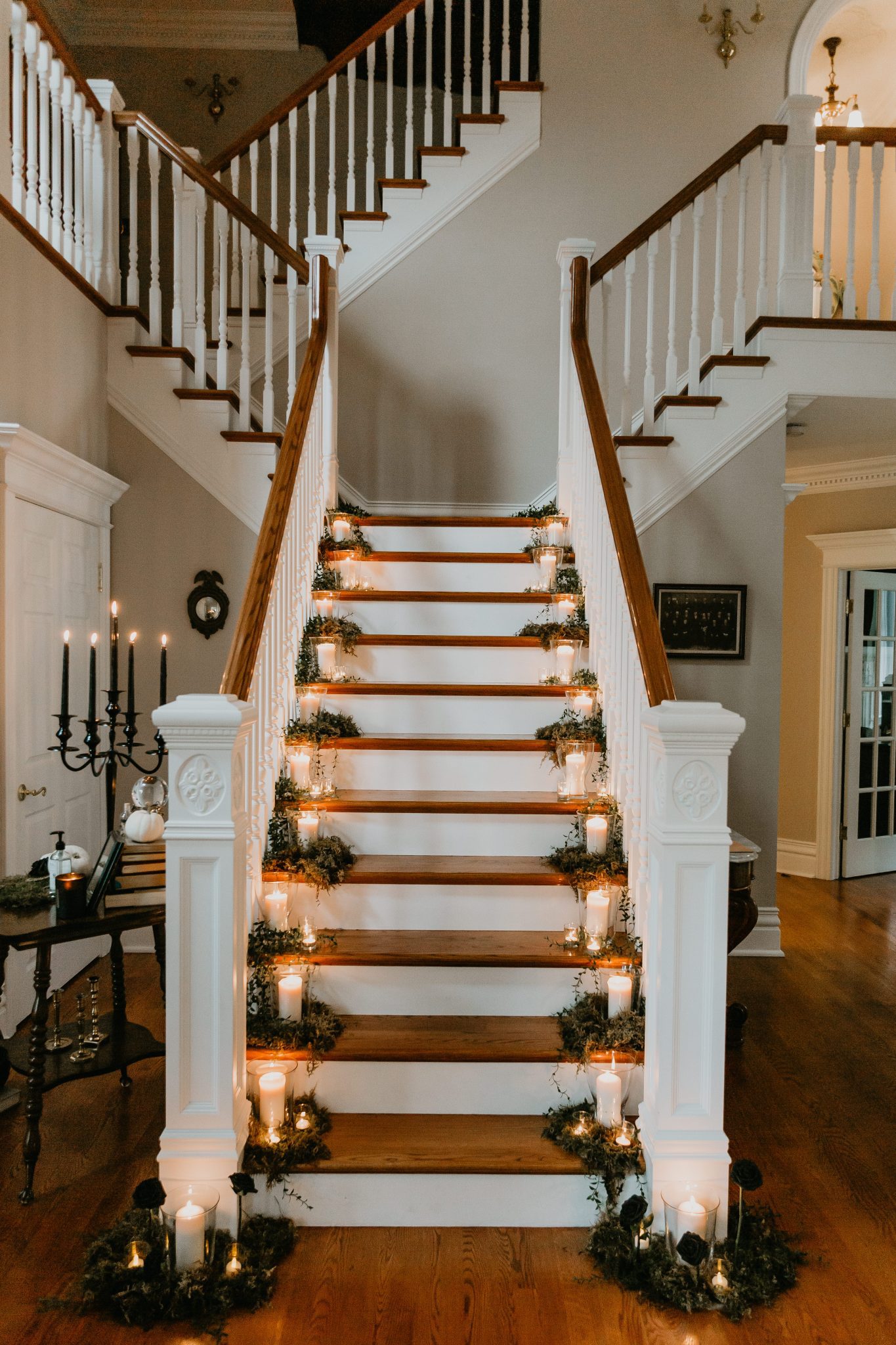 Living room minimony staircase lined with casscading candles and greenery