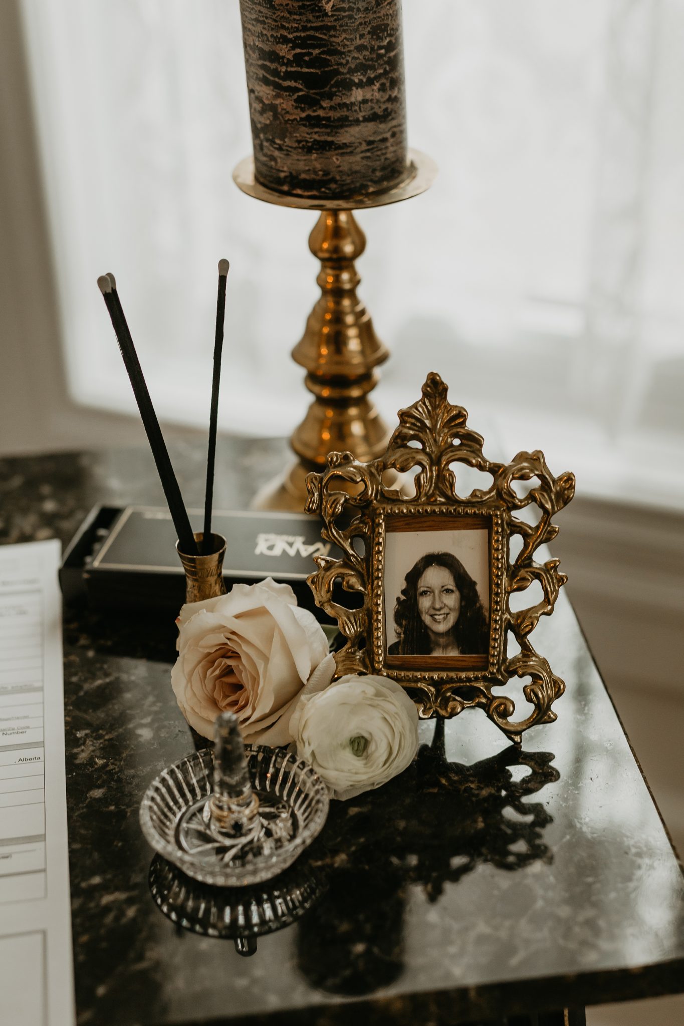 Framed photograph of a woman on a side table with roses