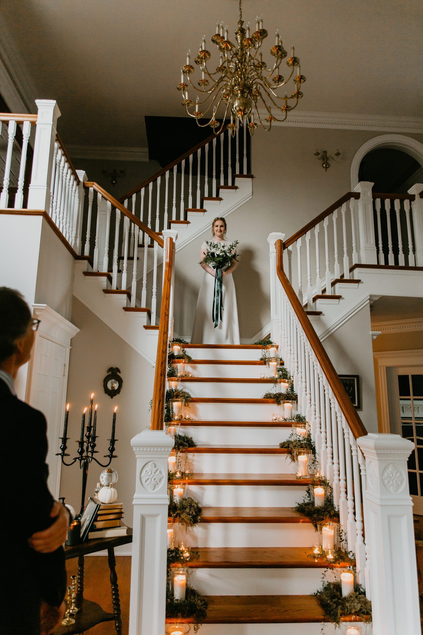 Bride stands at the top of a stair case ready to make her grand entrance for this modern living room minimony