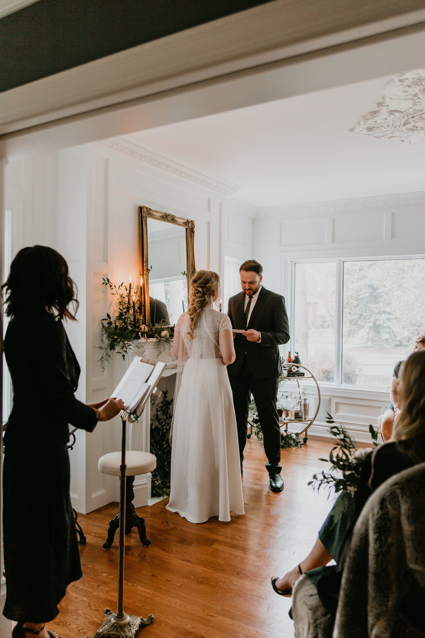 Bride and groom exchange vows during their living room minimony