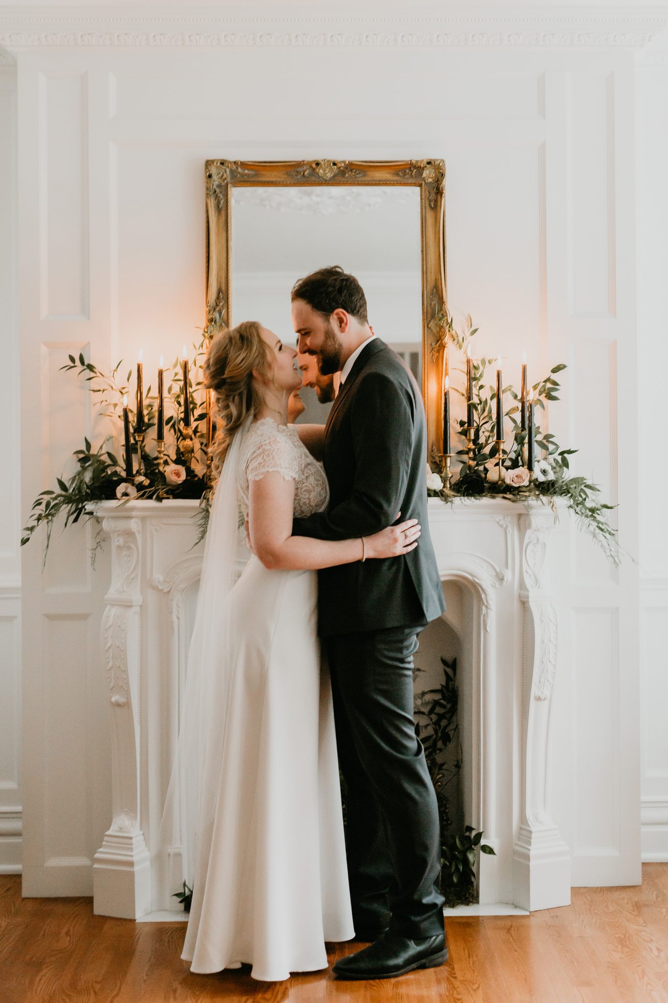 Bride and groom share a first dance in front of a styled fireplace for their living room minimony