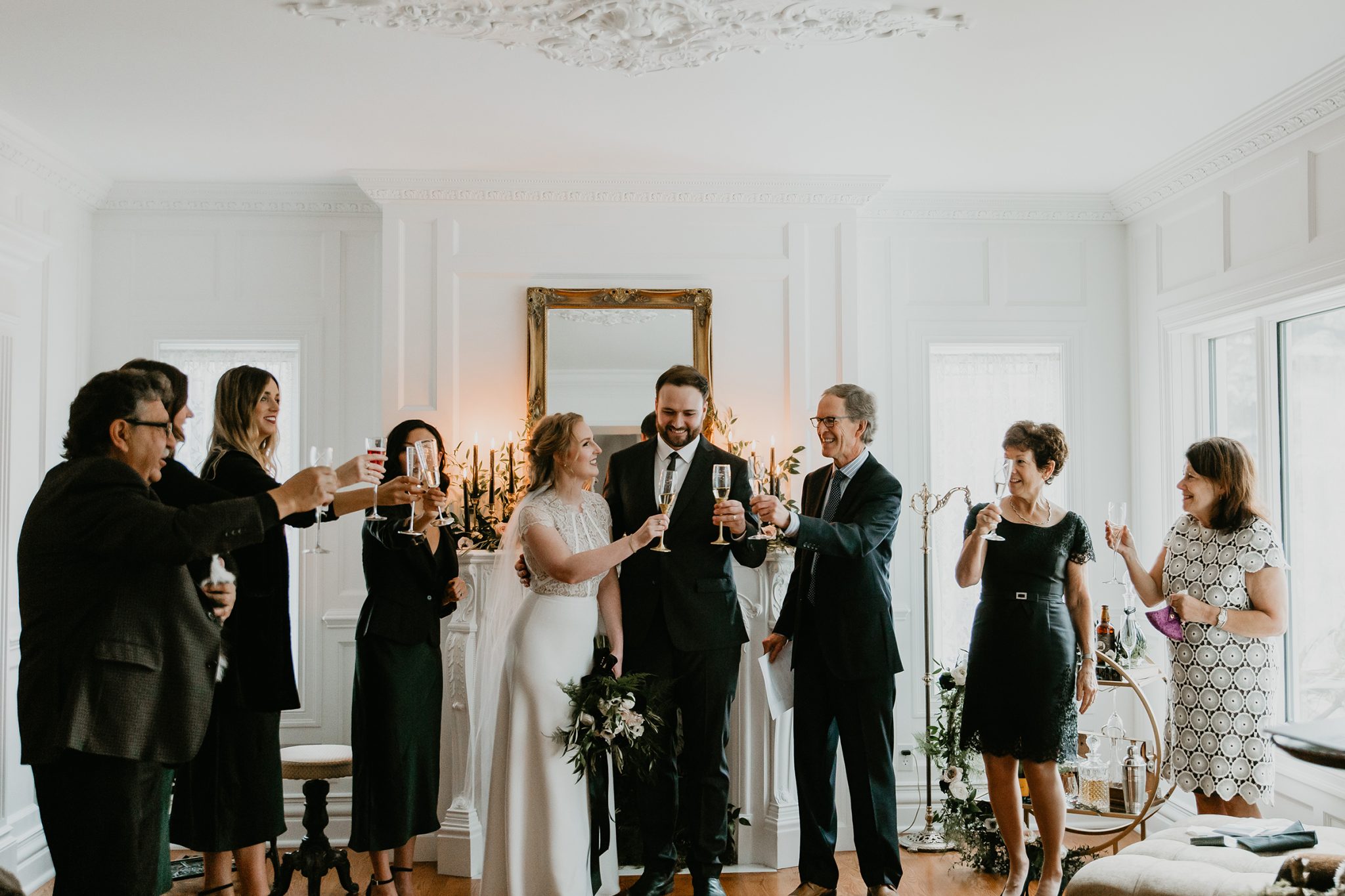 Family toasts the newly weds after their living room minimony