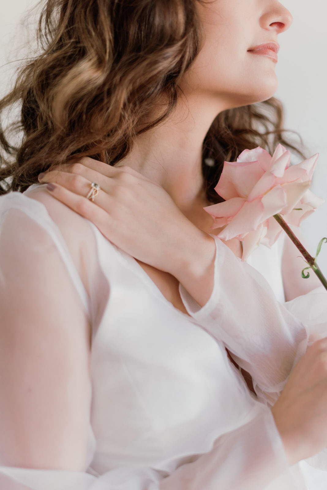 Bride poses with a pink garden rose 
