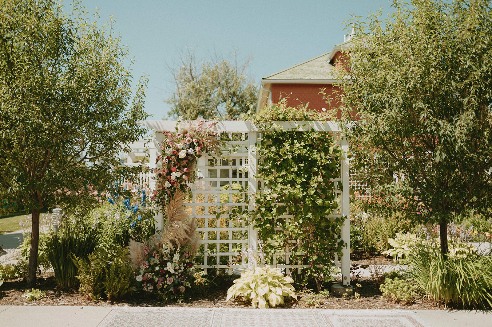 Summer wedding inspiration with a floral arch for an outdoor wedding ceremony at Deane House